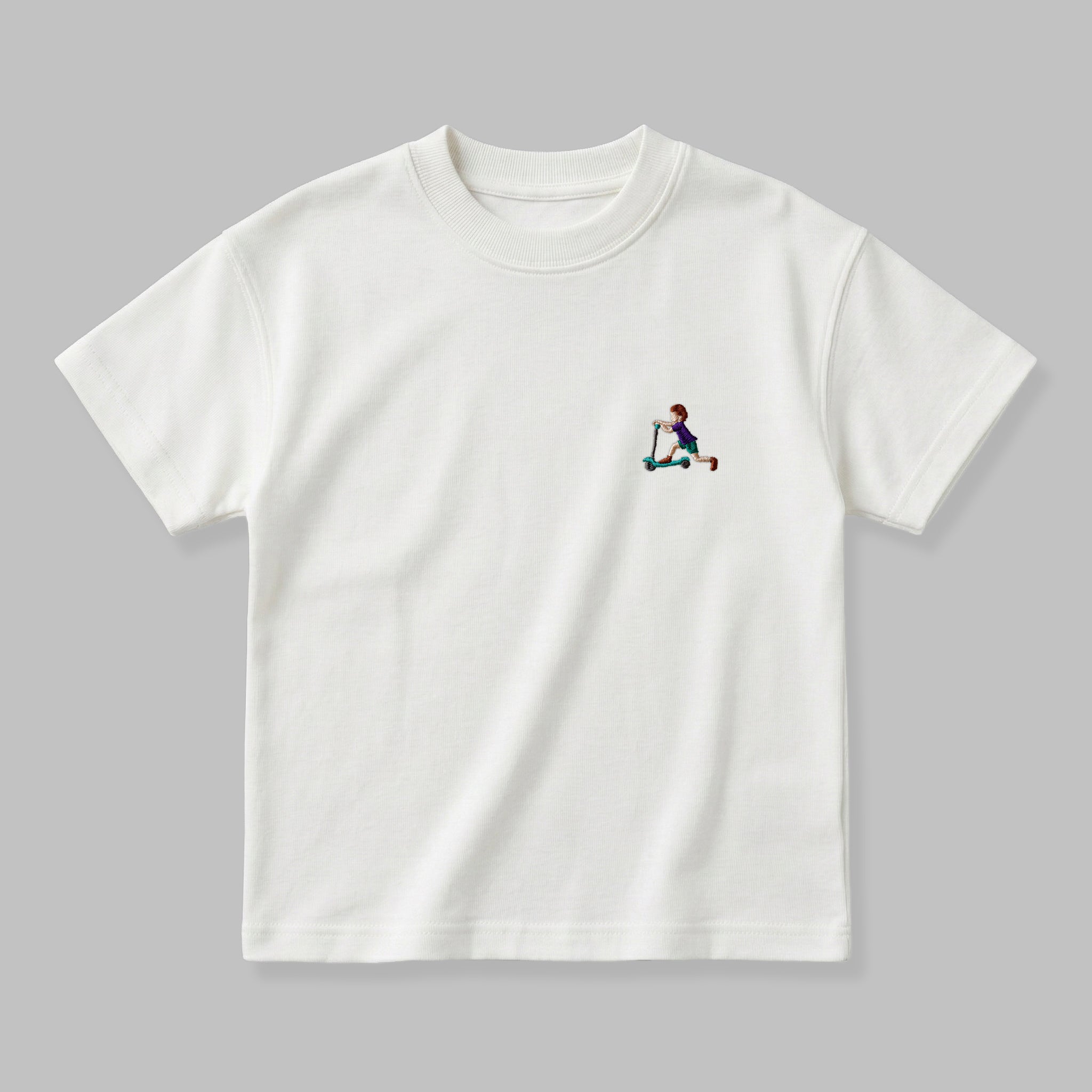 Kırık beyaz renkli, %100 pamuklu Oeko-Tex sertifikalı oversize çocuk t-shirt modeli. Göğüs kısmında şık, minimal ve rahatsız etmeyen ufak ebatlı "scootera binen çocuk" nakış detayı bulunur. Birinci sınıf Alman nakış ipliği kullanılarak özenle üretilmiştir. Tok duruşlu heavyweight kumaşı, nefes alan ve terletmeyen dokusuyla çocukların hassas cildine uygun, sade ve premium günlük giyim parçası.