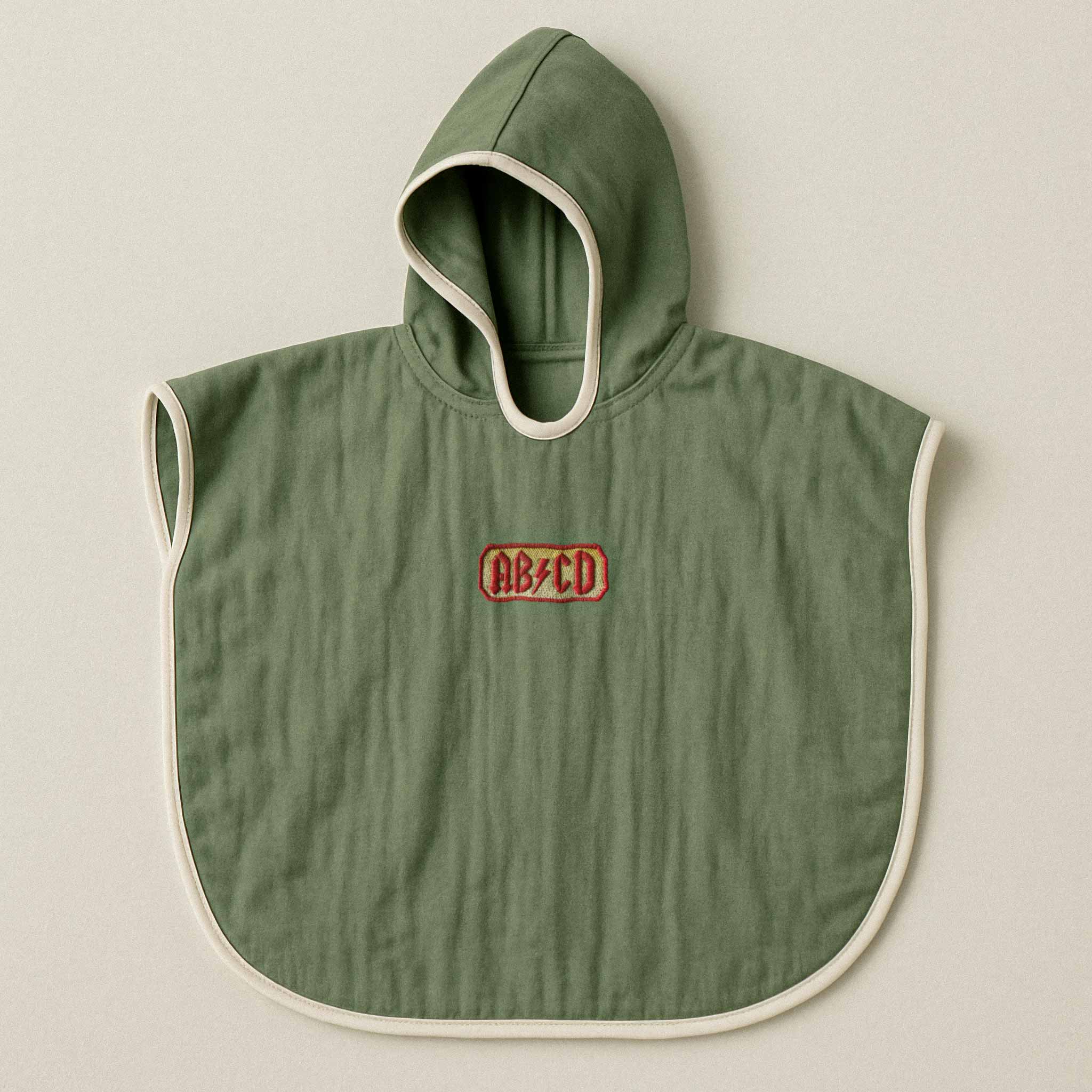 Haki yeşili renginde, kapüşonlu, müslin kumaştan bebek ve çocuk pançosu. Göğüs kısmında AC/DC logosu stilinde kırmızı "AB/CD" yazısı işlenmiştir.