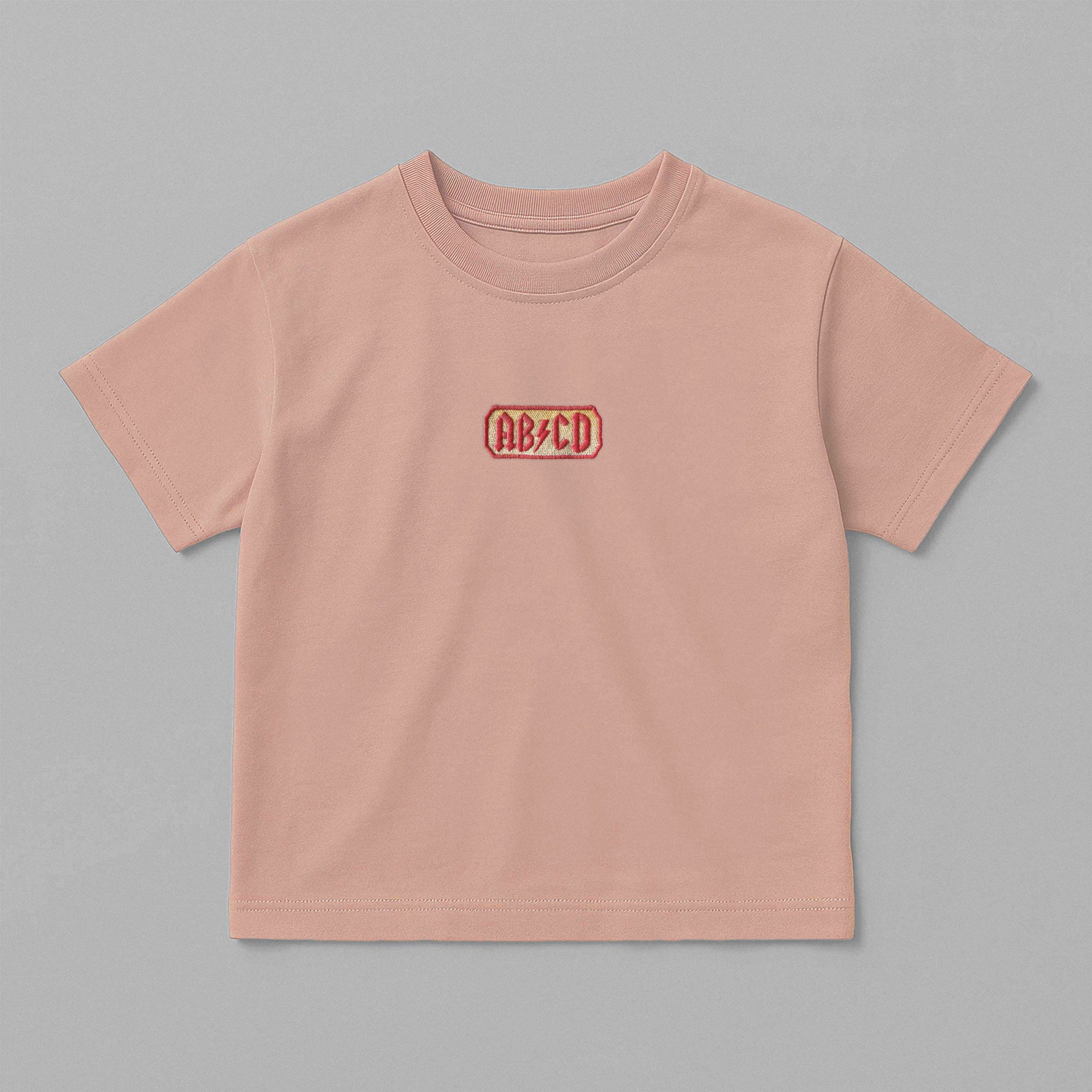 Gül kurusu (pembe) renkli, oversize kesim, 1-5 yaş için pamuklu çocuk tişörtü. Göğüs kısmında AC/DC logosu stilinde "AB/CD" nakışı bulunmaktadır.