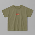 Haki yeşili, oversize kesim, 1-5 yaş için pamuklu çocuk tişörtü. Göğüs kısmında AC/DC logosu stilinde "AB/CD" nakışı bulunmaktadır.