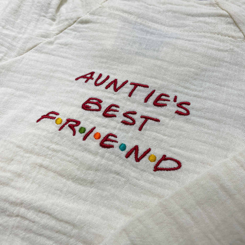 Doğal bej (ekru) renginde, %100 pamuklu müslin çocuk kimono takımı. Göğüs kısmında kırmızı iplik ve renkli noktalarla işlenmiş eğlenceli "AUNTIE'S BEST FRIEND" nakışı yer alır. Hassas ciltlere dost, nefes alan ve terletmeyen hafif dokusuyla öne çıkan, konforlu premium bebek ve çocuk takımı.
