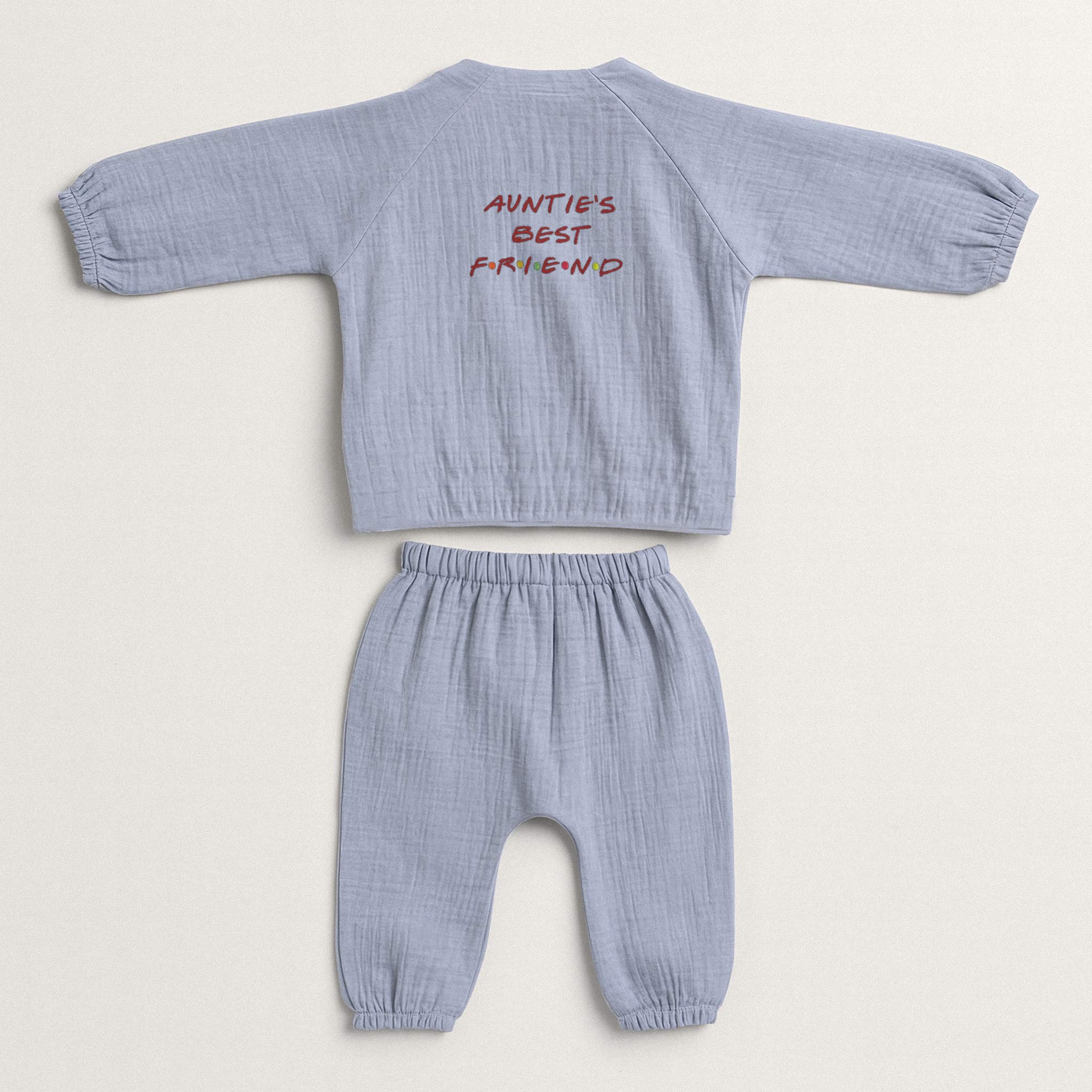 İndigo mavisi renginde, müslin kumaştan yapılmış, üzerinde "Auntie's Best Friend" baskısı bulunan, yandan bağlamalı kimono üst ve pantolondan oluşan yenidoğan bebek takımı.