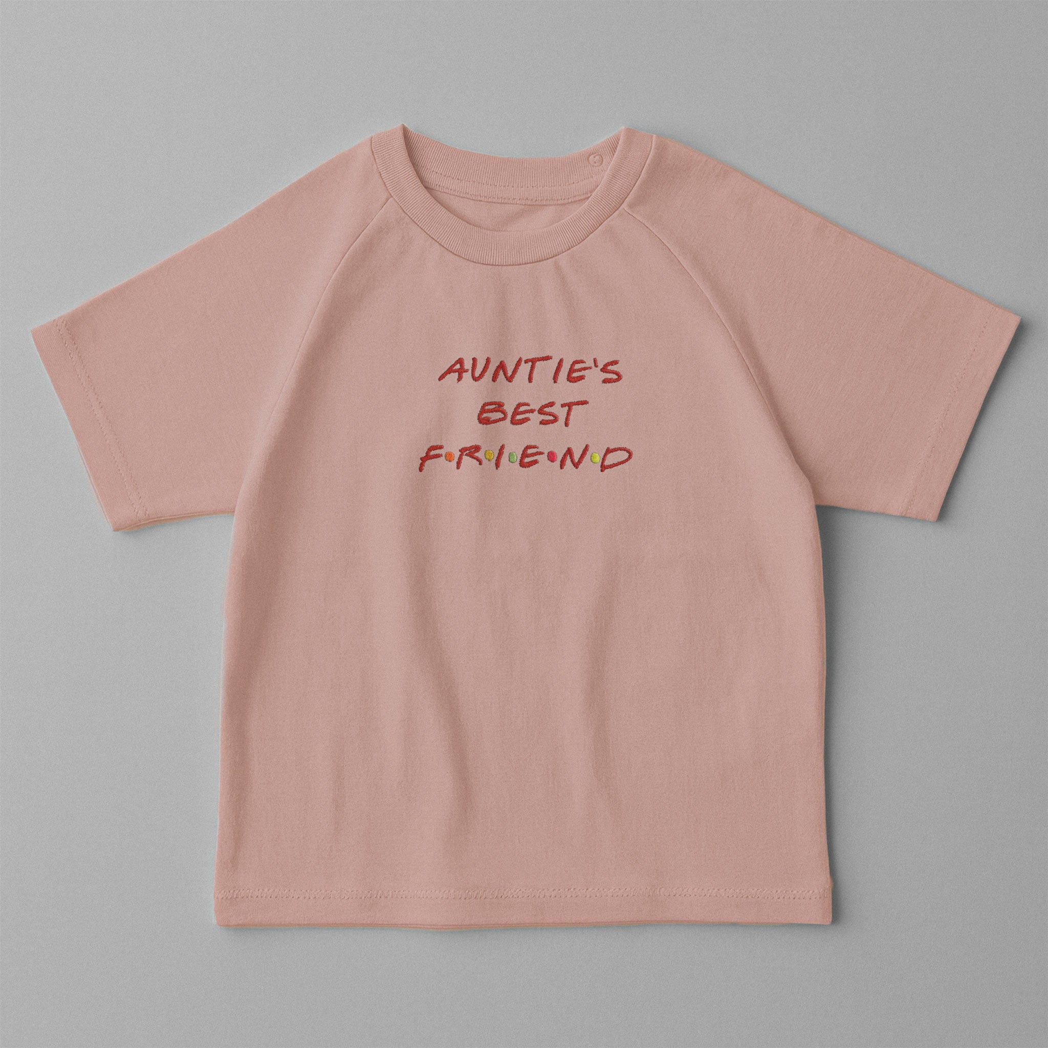 Gül kurusu (pembe) renkli, omuzdan çıtçıtlı, üzerinde Friends dizisi stiliyle 'AUNTIE'S BEST FRIEND' nakışı bulunan oversize pamuklu bebek tişörtü.