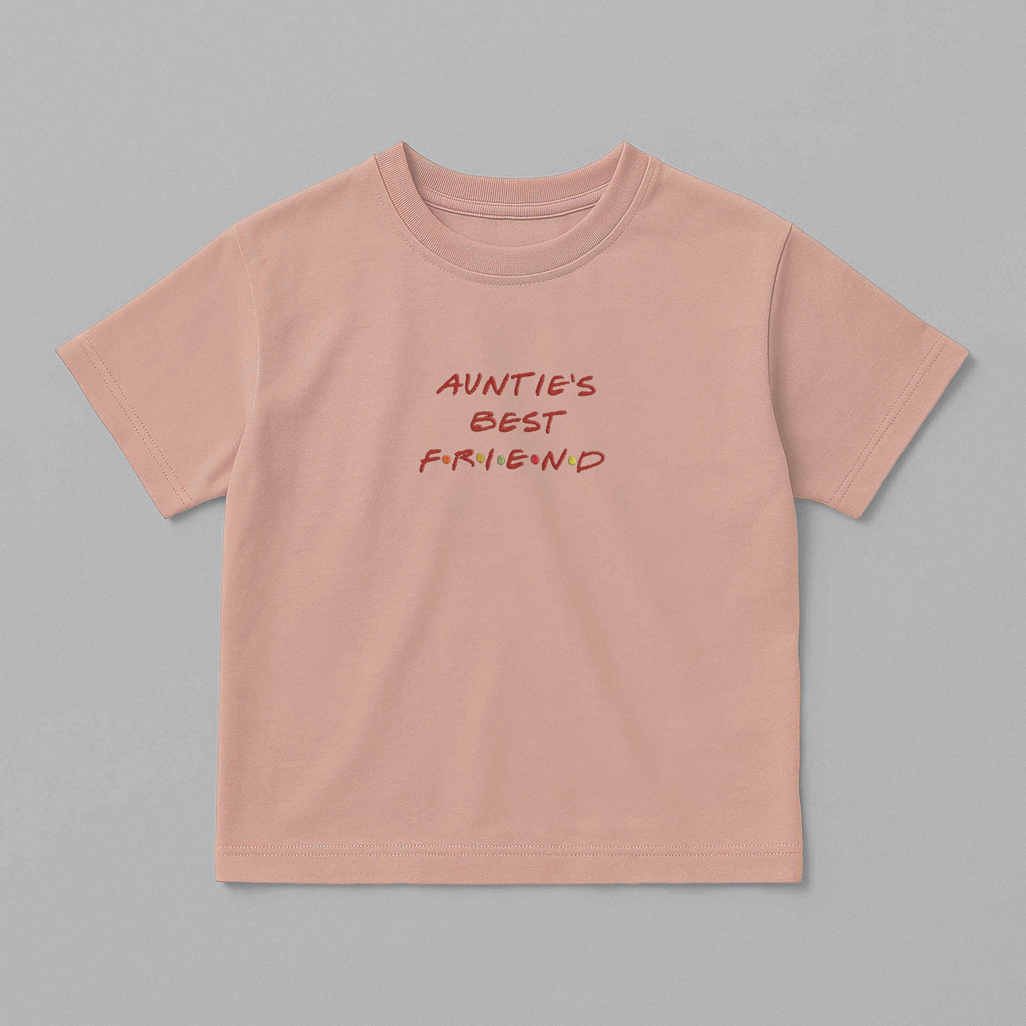 Gül kurusu (pembe) renkli, oversize kesim, üzerinde kırmızı harfler ve renkli detaylarla Friends dizisi fontunda 'AUNTIE'S BEST FRIEND' nakışı bulunan pamuklu çocuk tişörtü.