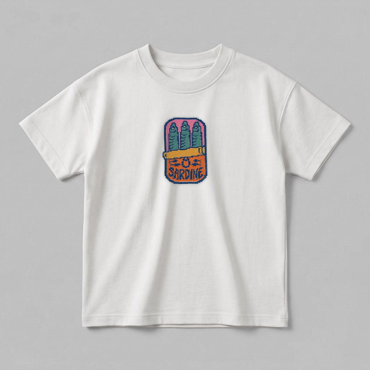 Beyaz renkli, %100 pamuklu Oeko-Tex sertifikalı oversize çocuk t-shirt modeli. Göğüs kısmında canlı renklerle tasarlanmış, pixel art estetiğini kanaviçe (cross stitch) tekniğiyle buluşturan konserve sardalya nakış detayı bulunur. Birinci sınıf Alman nakış ipliği kullanılarak yüksek kalite standartlarında işlenmiştir. Tok duruşlu heavyweight kumaşı, nefes alan ve terletmeyen dokusuyla çocukların hassas cildine uygun, şık ve premium günlük giyim parçası.