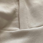 Beyaz renkli premium yetişkin hoodie modelinin yaka kısmı ve kapüşon birleşim noktasını gösteren makro detay çekimi. Kaliteli tok pamuklu kumaşın yoğun örgüsü ve kapüşonu gövdeye bağlayan pürüzsüz, sağlam dikiş işçiliği ön plana çıkmaktadır. Hem tok bir duruş hem de uzun ömürlü kullanım sunan kusursuz bir yapısal detaydır.