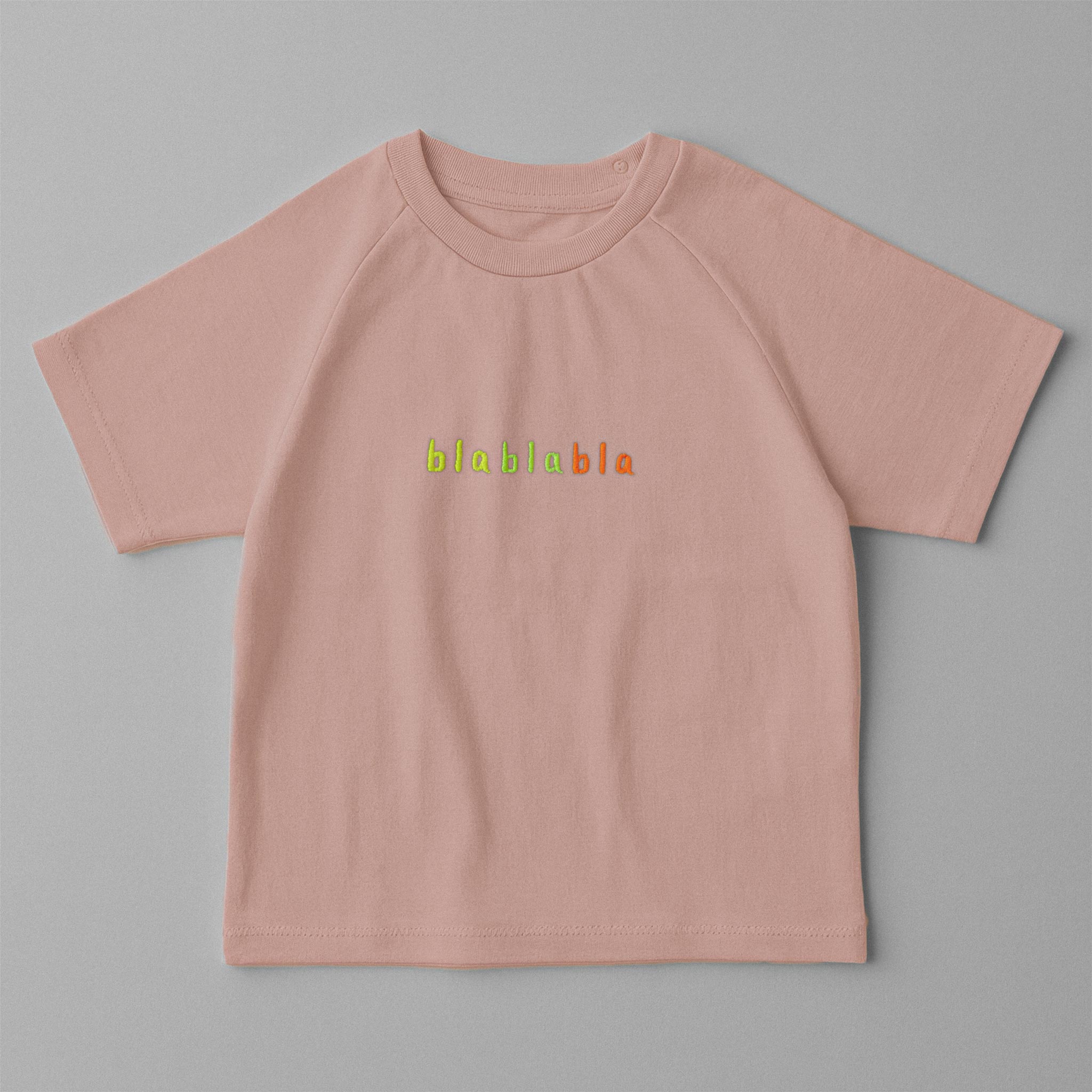 Gül kurusu (pembe) renkli, reglan kollu, omuzdan çıtçıtlı bebek tişörtü. Göğüs kısmında renkli ipliklerle "blablabla" nakışı bulunmaktadır.