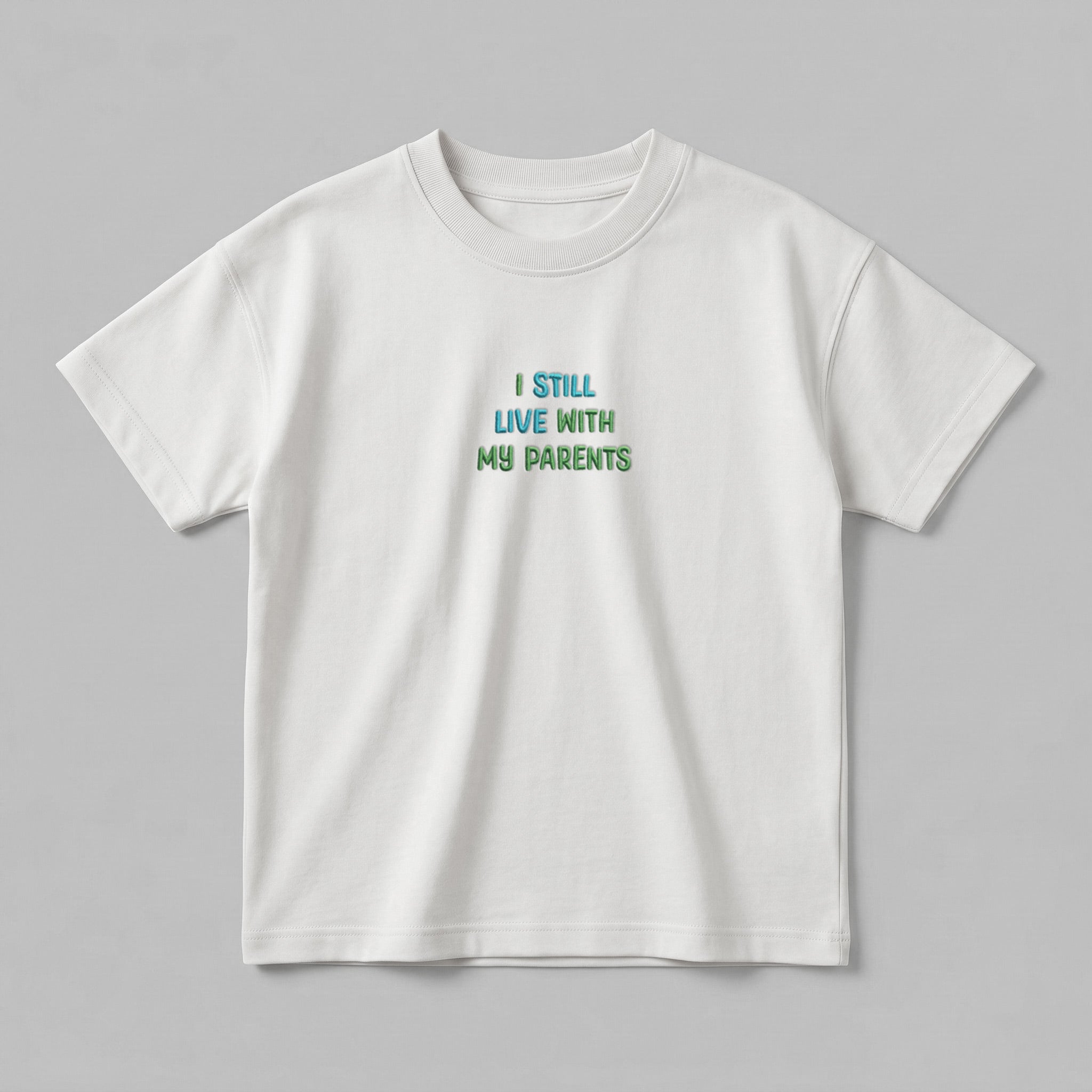 Ekru renkli, premium ağır gramajlı (heavyweight) kumaşıyla tok ve kaliteli bir duruş sergileyen oversize çocuk tişörtü. Göğüs kısmında renkli nakış tekniğiyle işlenmiş "I STILL LIVE WITH MY PARENTS" tasarımı bulunur. %100 pamuklu ve Oeko-Tex belgeli yapısı, çocukların hassas cildine nefes aldırırken üstün konfor sunar. Geniş ribana yaka detayı ve rahat kesimiyle 2-7 yaş arası çocuklar için her mevsim idealdir. Uzun ömürlü kullanım vaat eden, şık ve sağlıklı bir nakışlı çocuk giyim ürünüdür.