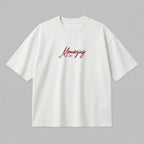Yetişkinler için ekru (krem) renkli premium loose fit kesim pamuk t-shirt kapak görseli. Sol göğüste kırmızı el yazısı fontuyla "Momazing est. 2026" nakış örneği yer alır. Bu model, anne olma yılınızı (maks. 8 karakter) Alman nakış kalitesiyle özelleştirerek size özel bir parça oluşturmanızı sağlar. %100 pamuklu, heavyweight tok kumaşı formunu korurken loose fit kesim ile gün boyu konfor ve stil sunar. Kendinize has bir premium giyim ürünü tasarlamak için mükemmeldir.