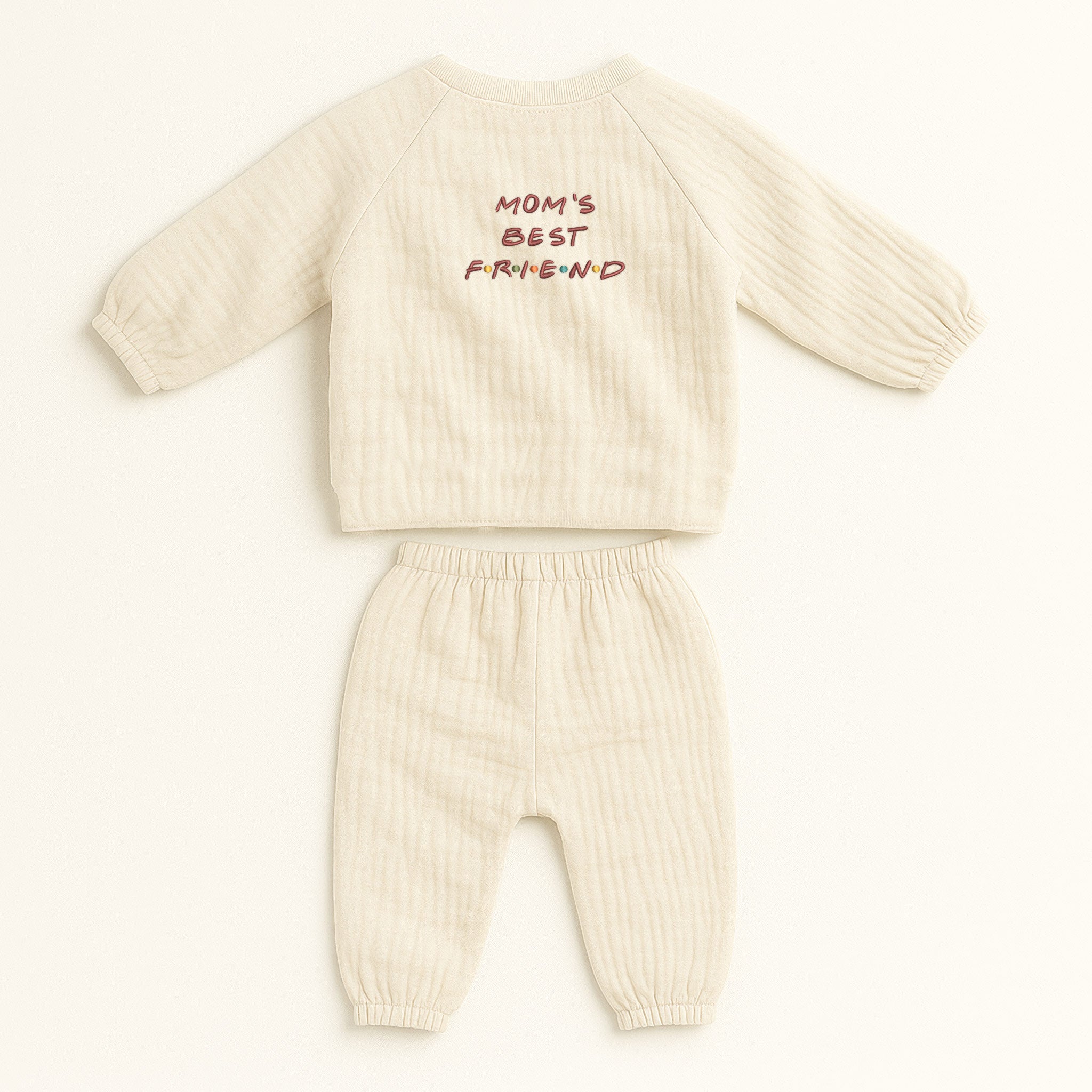 Ekru renkli, %100 pamuklu Oeko-Tex sertifikalı müslin kumaştan çocuk alt-üst kimono takımı. Üst parçanın sırt kısmında kırmızı renkli "MOM'S BEST" yazısı ve hemen altında renkli noktalarla detaylandırılmış "F.R.I.E.N.D" nakışı bulunur. Alman nakış işçiliği ile üretilmiştir. Doğal, nefes alan ve terletmeyen hafif müslin dokusu ile esnek belli alt parçası çocuklara hareket özgürlüğü sağlar. Anneler ve çocukları arasındaki bağı yansıtan, günlük kullanıma uygun tasarım.