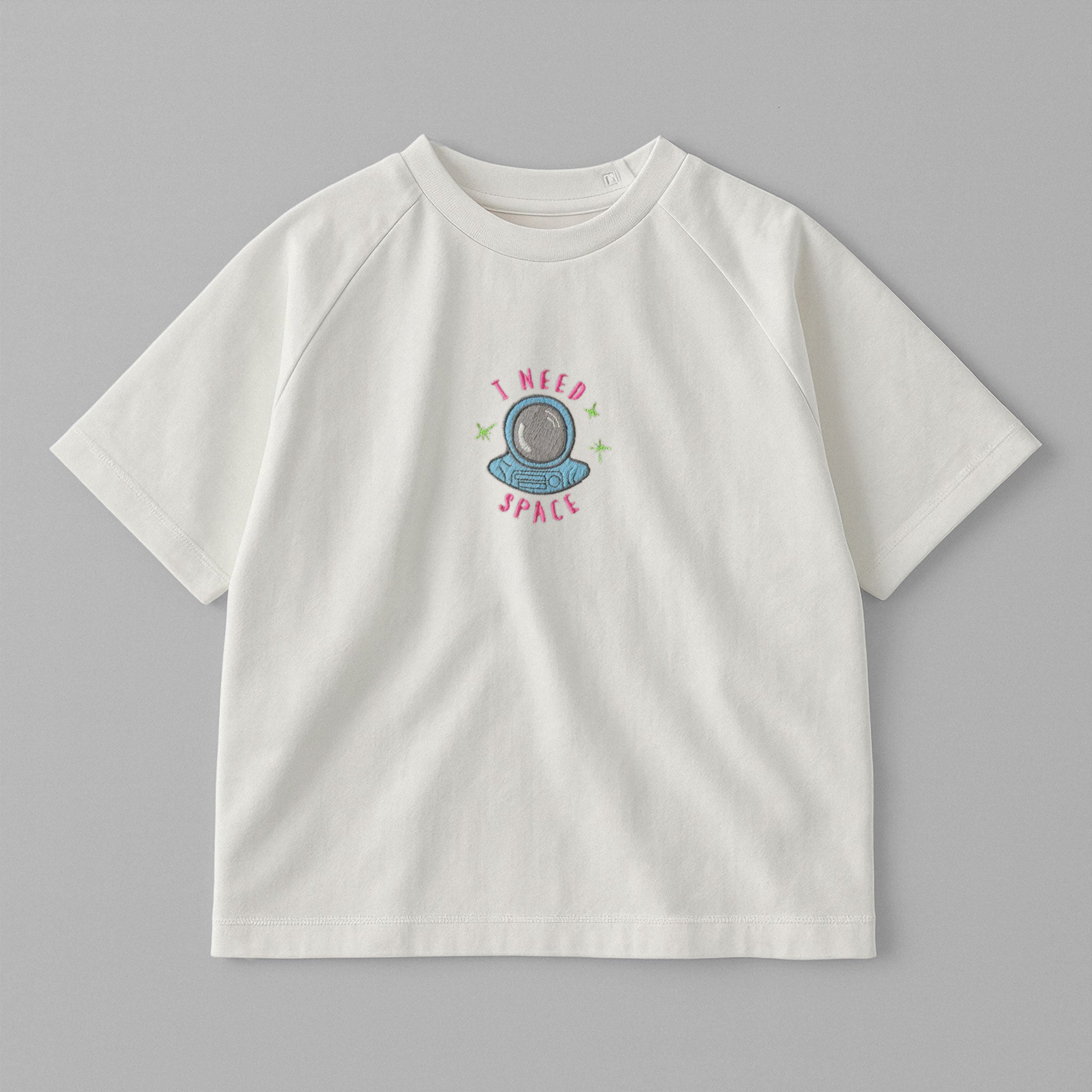 Ekru renkli, reglan kollu, omuzdan çıtçıtlı bebek tişörtü. Göğüs kısmında astronot kaskı çizimi ve "I NEED SPACE" nakışı bulunmaktadır.