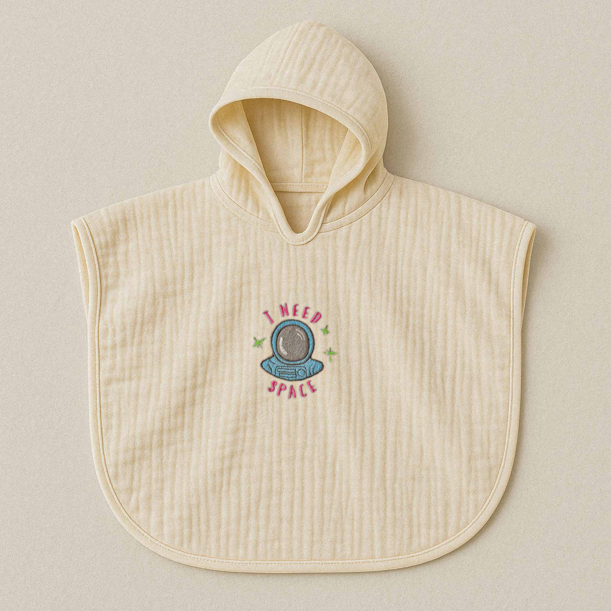 Ekru (doğal bej) renginde, kapüşonlu, müslin kumaştan bebek ve çocuk pançosu. Göğüs kısmında astronot kaskı çizimi ve "I NEED SPACE" yazısı işlenmiştir.