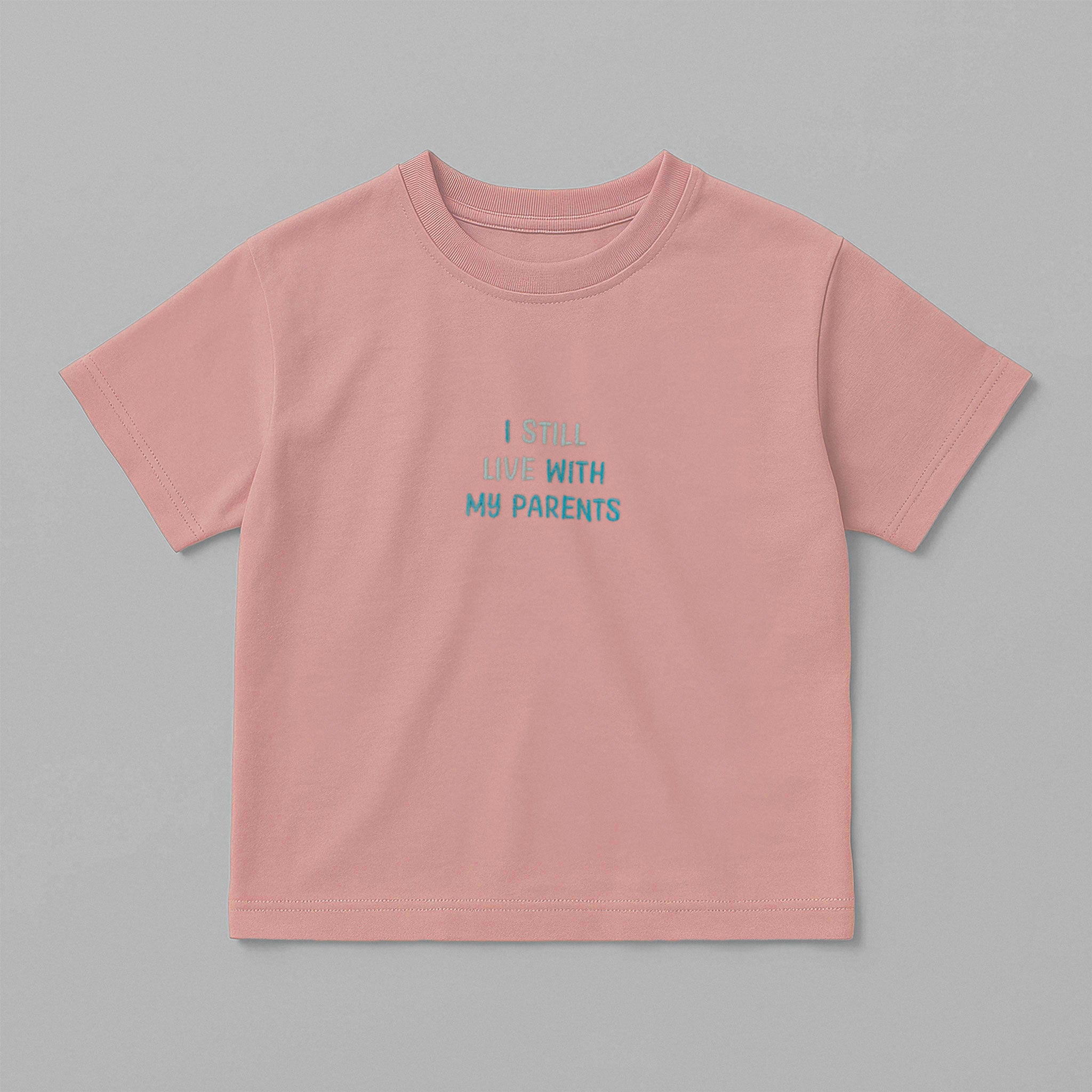 Gül kurusu (pembe) renkli, oversize kesim, 1-5 yaş için pamuklu çocuk tişörtü. Göğüs kısmında mavi tonlarda "I STILL LIVE WITH MY PARENTS" nakışı bulunmaktadır.