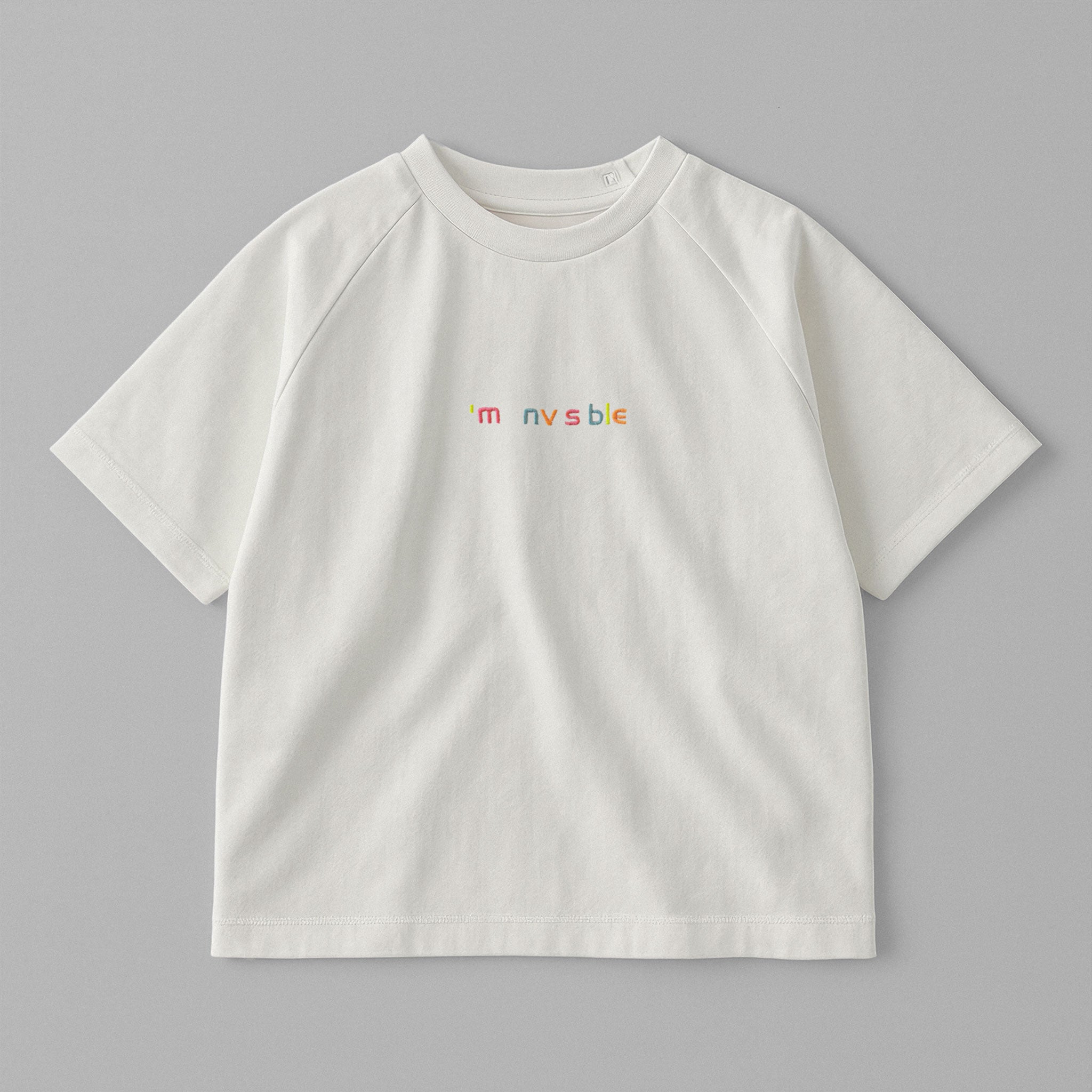 Ekru renkli, reglan kollu, omuzdan çıtçıtlı bebek tişörtü. Göğüs kısmında renkli ipliklerle "I'm nvsble" nakışı bulunmaktadır.