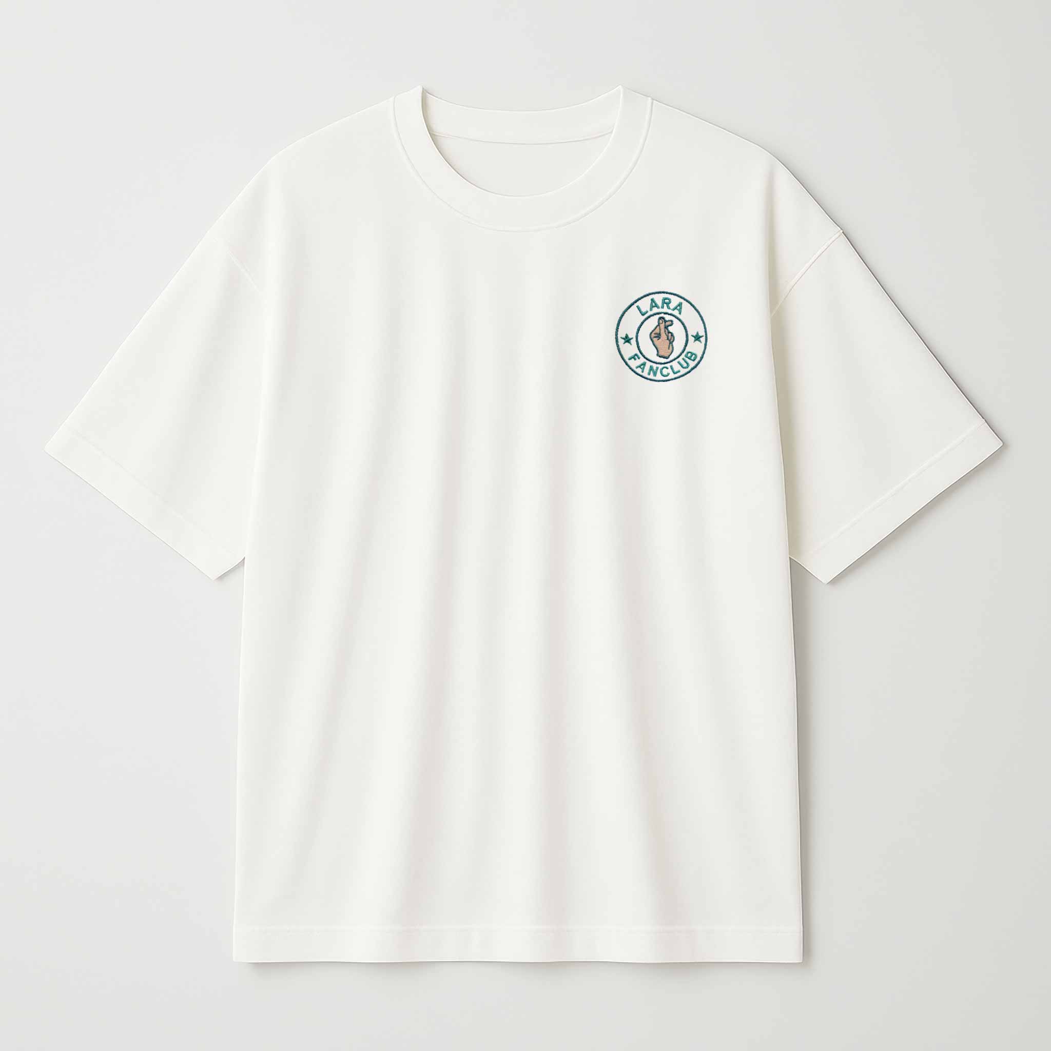 Krem (ekru) renkli, oversize kesim, Bona Pera marka pamuklu tişört. Sol göğüs kısmında, "LARA FANCLUB" yazılı, mavi ve ten rengi iplikle işlenmiş, kişiselleştirilebilir isimli nakış logo bulunmaktadır.