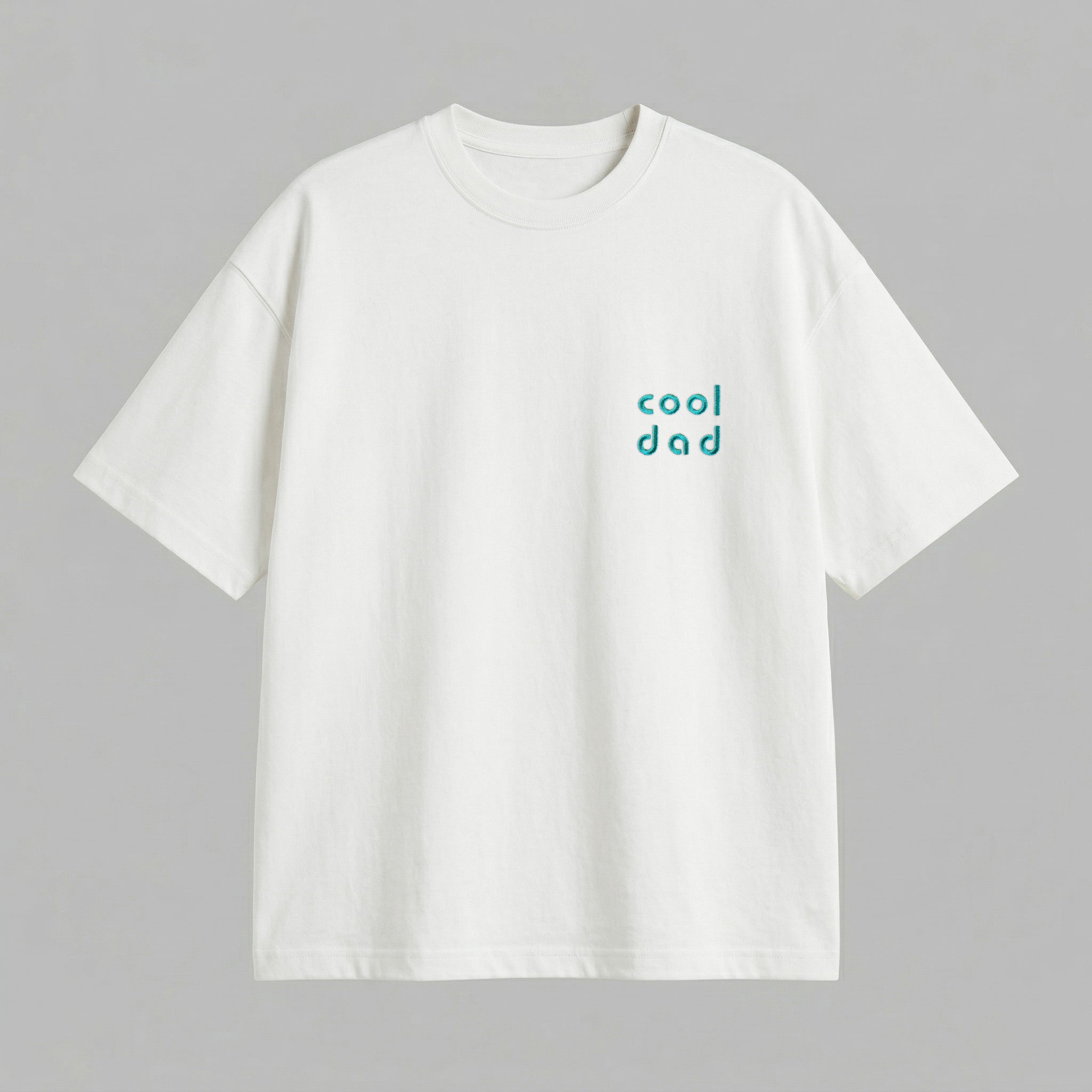 Kırık beyaz renkli %100 pamuklu Oeko-Tex sertifikalı loose fit erkek tişörtü. Sol göğüs kısmında turkuaz/petrol mavisi iplikle, modern ve yuvarlak hatlı minimal fontla işlenmiş "cool dad" nakışı yer alır. Birinci sınıf Alman nakış işçiliği ile özenle üretilmiştir. Tok duruşlu heavyweight kumaşı, nefes alan ve terletmeyen yapısıyla gün boyu rahatlık sunar. Babalar için tasarlanmış modern, sade ve premium günlük tişört tasarımı.