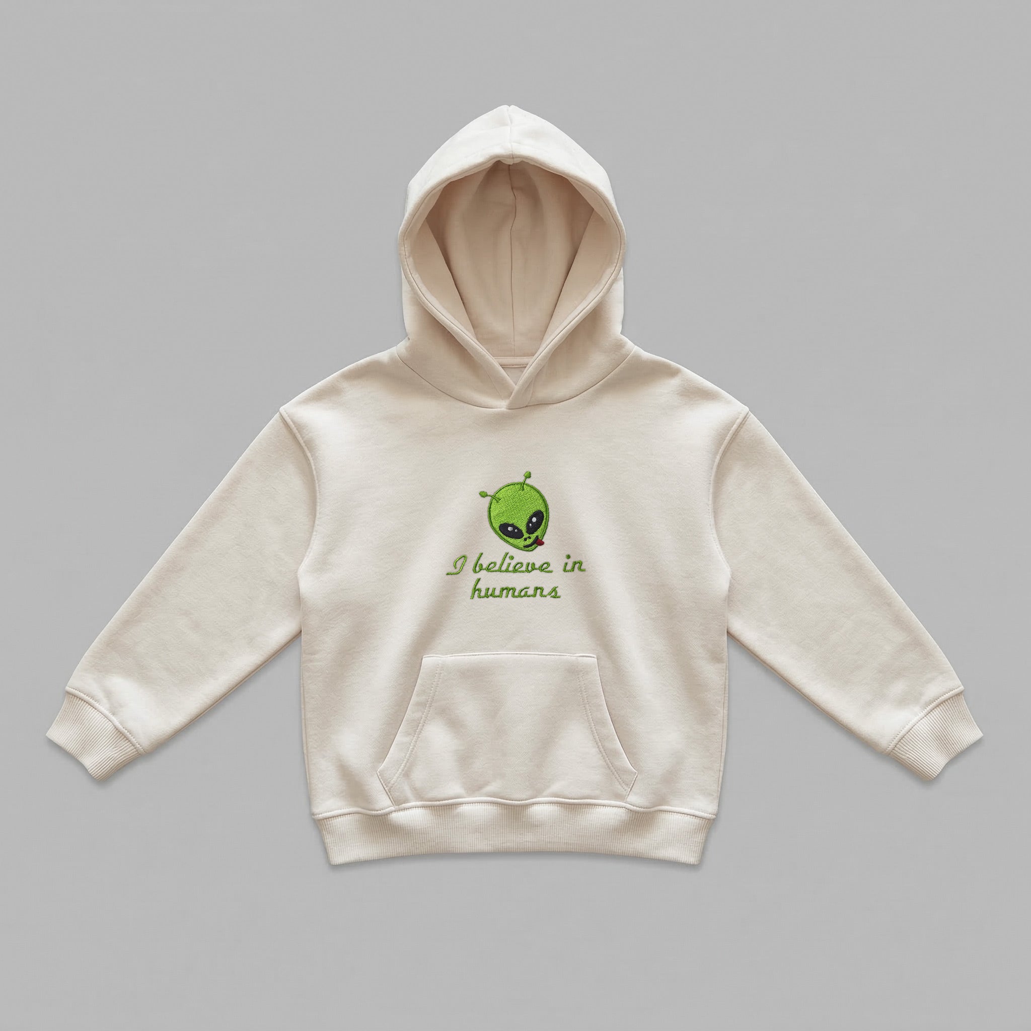 Kırık beyaz renkli, Oeko-Tex sertifikalı kalın polar polar çocuk kapüşonlu sweatshirt (hoodie). Göğüs kısmında dil çıkaran sevimli yeşil uzaylı kafası ve "I believe in humans" yeşil nakışlı yazısı bulunur. Kapüşon detayı görünmemekle birlikte, kumaş dokusu kalın polar polar dokuya sahiptir ve içi şardonlu sıcak tutan ve terletmeyen yapısıyla kış ayları için idealdir. Yüksek kalite Alman nakış işçiliğiyle üretilmiş premium kışlık çocuk sweatshirt detayı. (Görselde kapüşon detayı görünmemekle birlikte, polar 