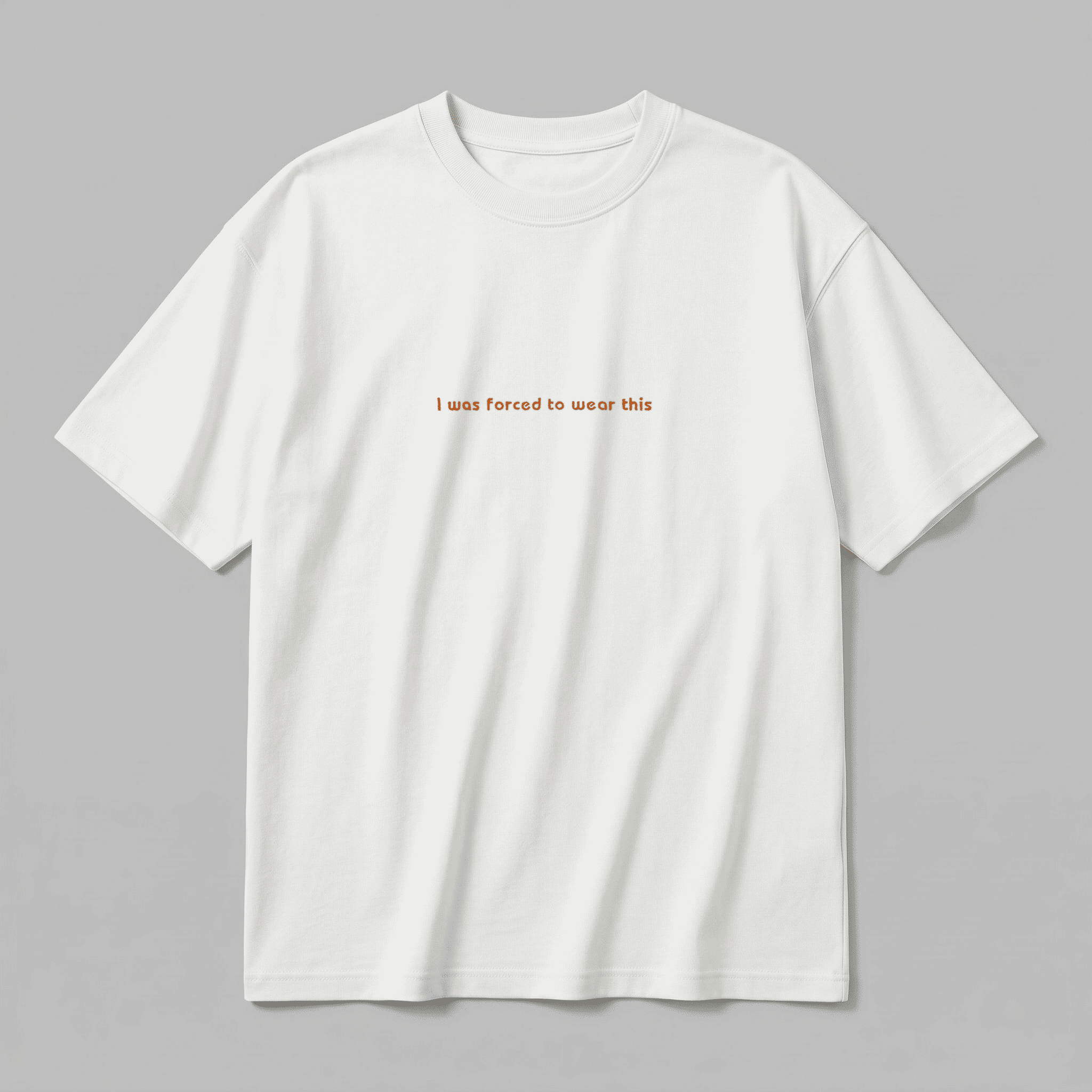 Kırık beyaz renkli %100 pamuklu Oeko-Tex sertifikalı loose fit erkek tişörtü. Göğüs kısmında kiremit renkli minimal fontla işlenmiş "I was forced to wear this" nakışı yer alır. Birinci sınıf Alman nakış işçiliğiyle üretilmiştir. Heavyweight kumaşı tok durur, terletmez. Babalar için tasarlanmış esprili ve premium günlük tişört.
