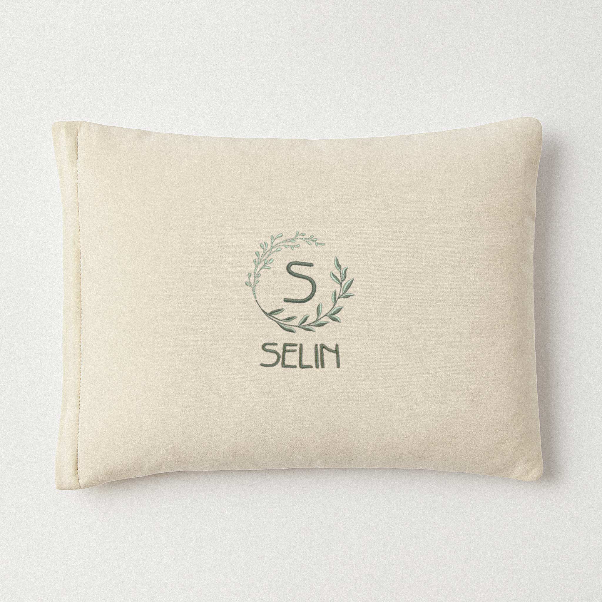 Ekru renkli, pamuklu bebek yastık kılıfı. Üzerinde çelenk içinde 'S' harfi ve altında 'Selin' ismi nakışla işlenmiştir (Harf ve isim kişiselleştirilebilir).