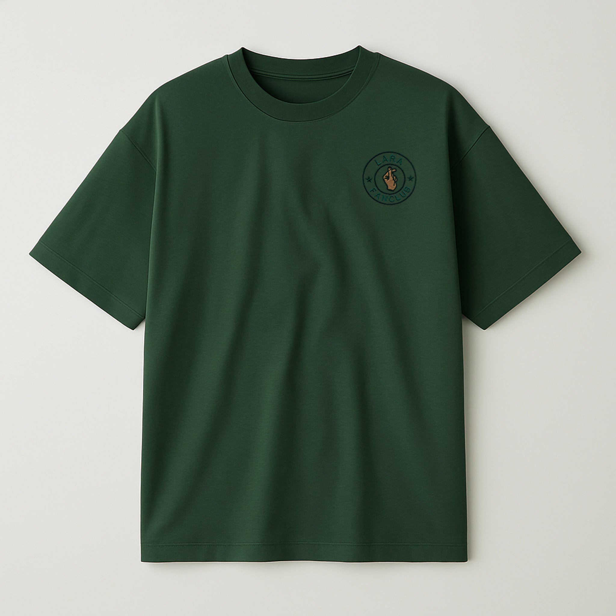 Koyu yeşil renkli, oversize kesim, sol göğüs kısmında yeşil daire içinde kişiselleştirilebilir isim ve 'Fan Club' yazısı ile kalp işareti yapan el nakışı bulunan pamuklu unisex tişört.