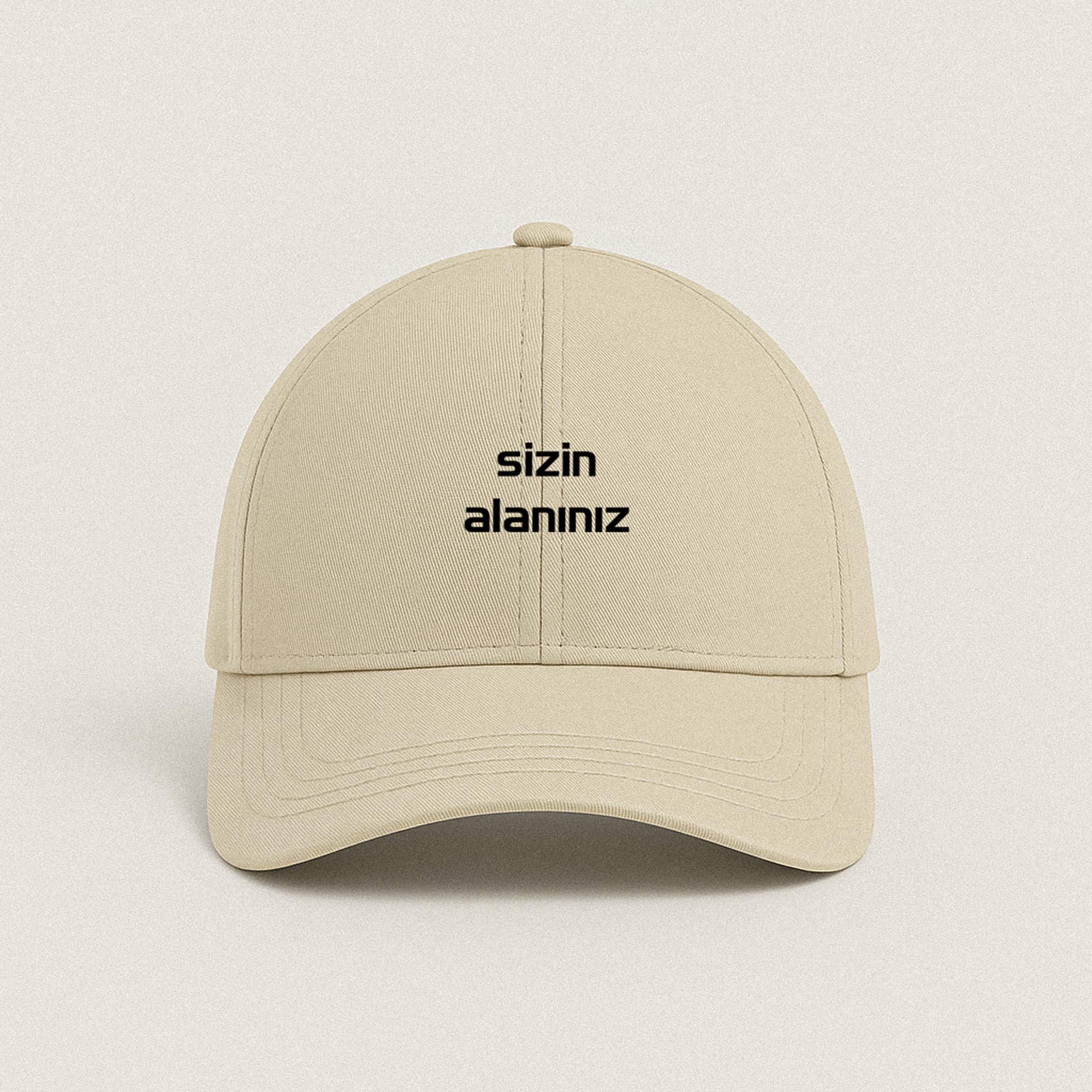 Bej renkli, ön kısmındaki alana müşterinin istediği yazının veya ismin nakışla işlenebildiği kişiye özel unisex şapka.