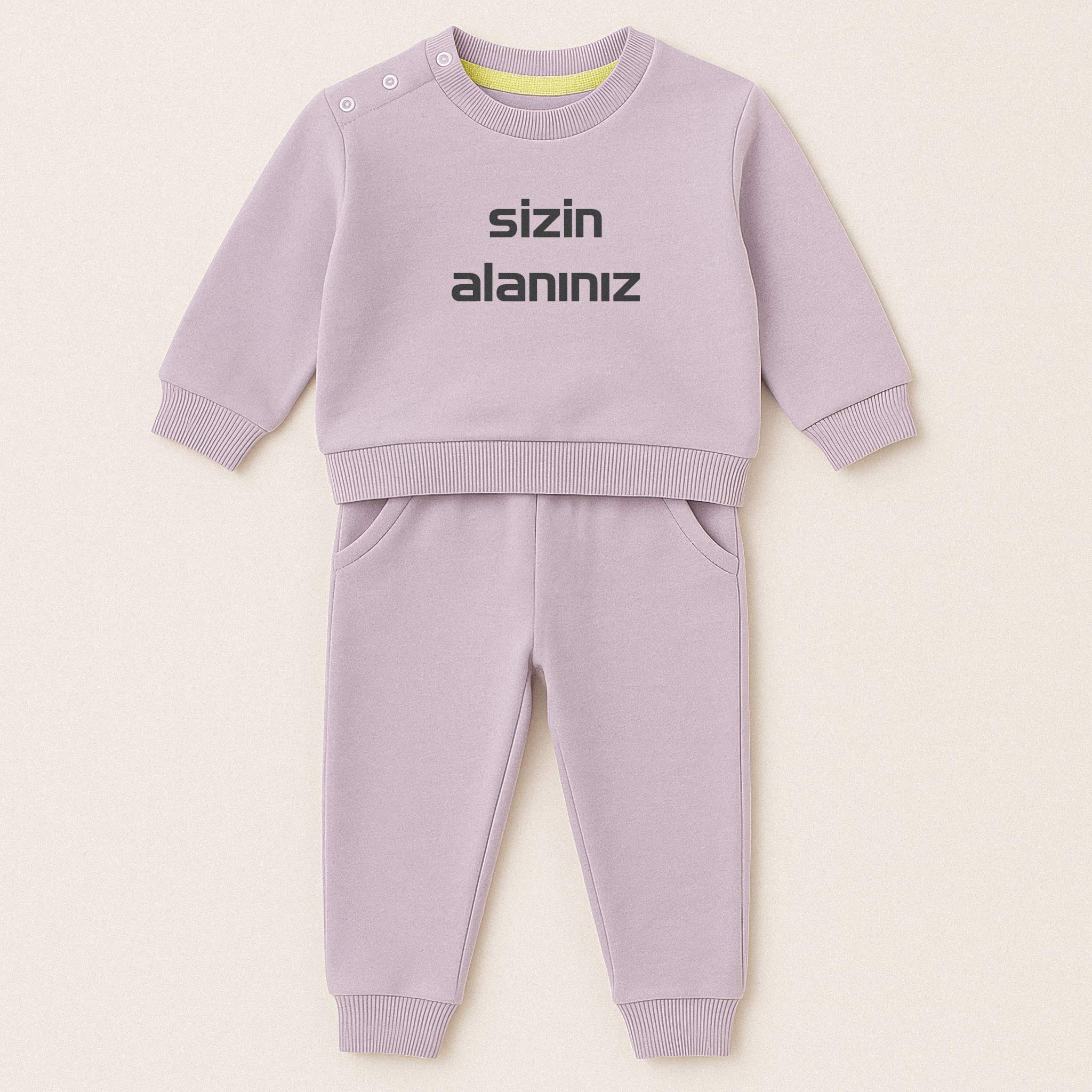 Lila (leylak) renkli, sweatshirt ve pantolondan oluşan, üzerine istenilen yazının nakışla işlenebildiği, omuzdan çıtçıtlı pamuklu bebek eşofman takımı.