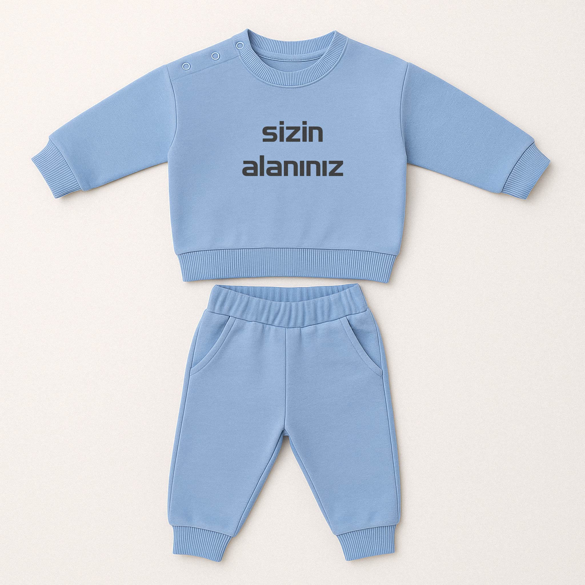 Mavi renkli, sweatshirt ve pantolondan oluşan, üzerine istenilen yazının nakışla işlenebildiği, omuzdan çıtçıtlı pamuklu bebek eşofman takımı.