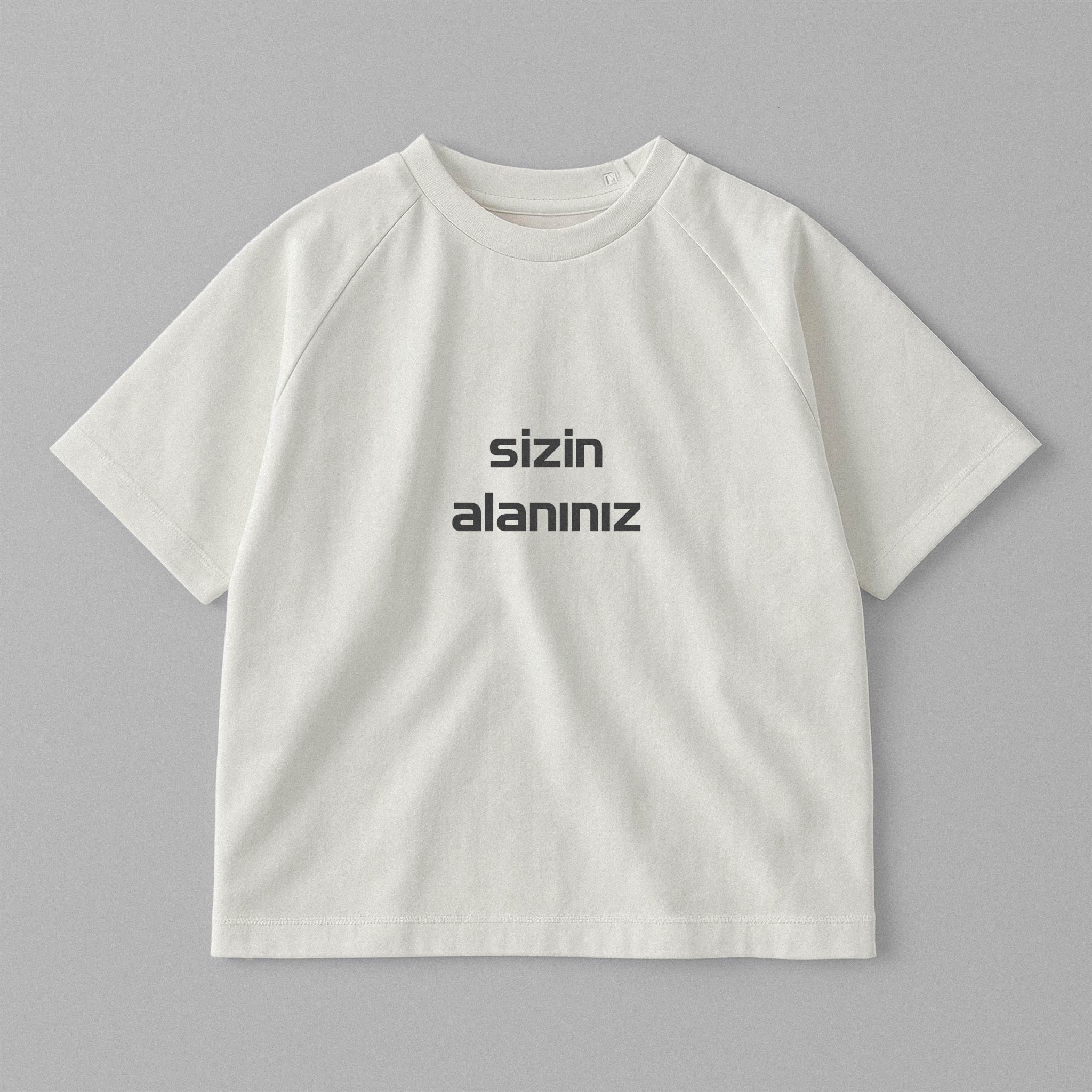 Ekru renkli, reglan kollu, omuzdan çıtçıtlı, üzerine istenilen yazının nakışla işlenebildiği pamuklu oversize bebek tişörtü.