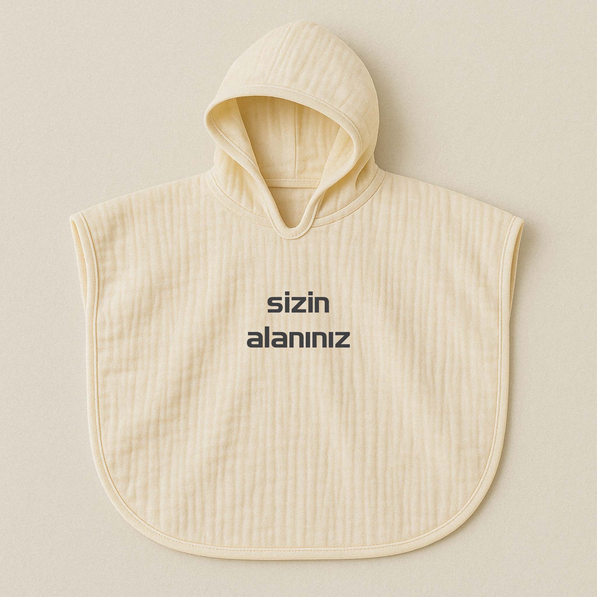 Ekru (doğal bej) renginde, kapüşonlu, müslin kumaştan, üzerine istenilen yazının nakışla işlenebildiği bebek ve çocuk pançosu.