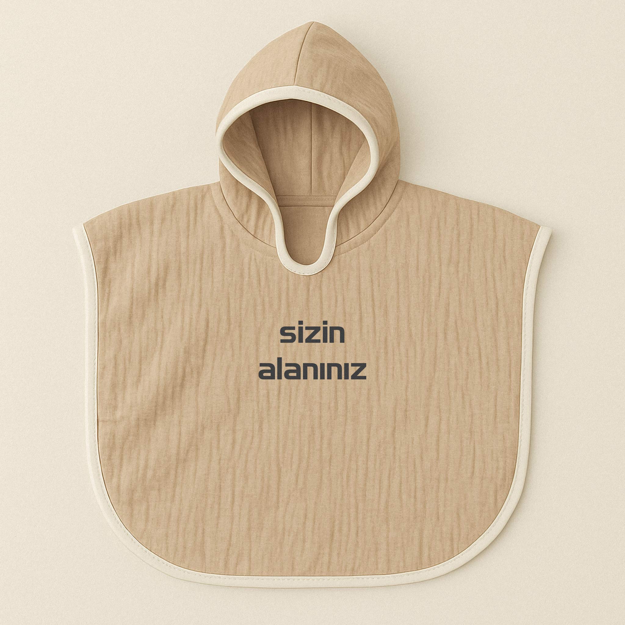 Somon rengi (bej), kapüşonlu, müslin kumaştan, üzerine istenilen yazının nakışla işlenebildiği bebek ve çocuk pançosu.