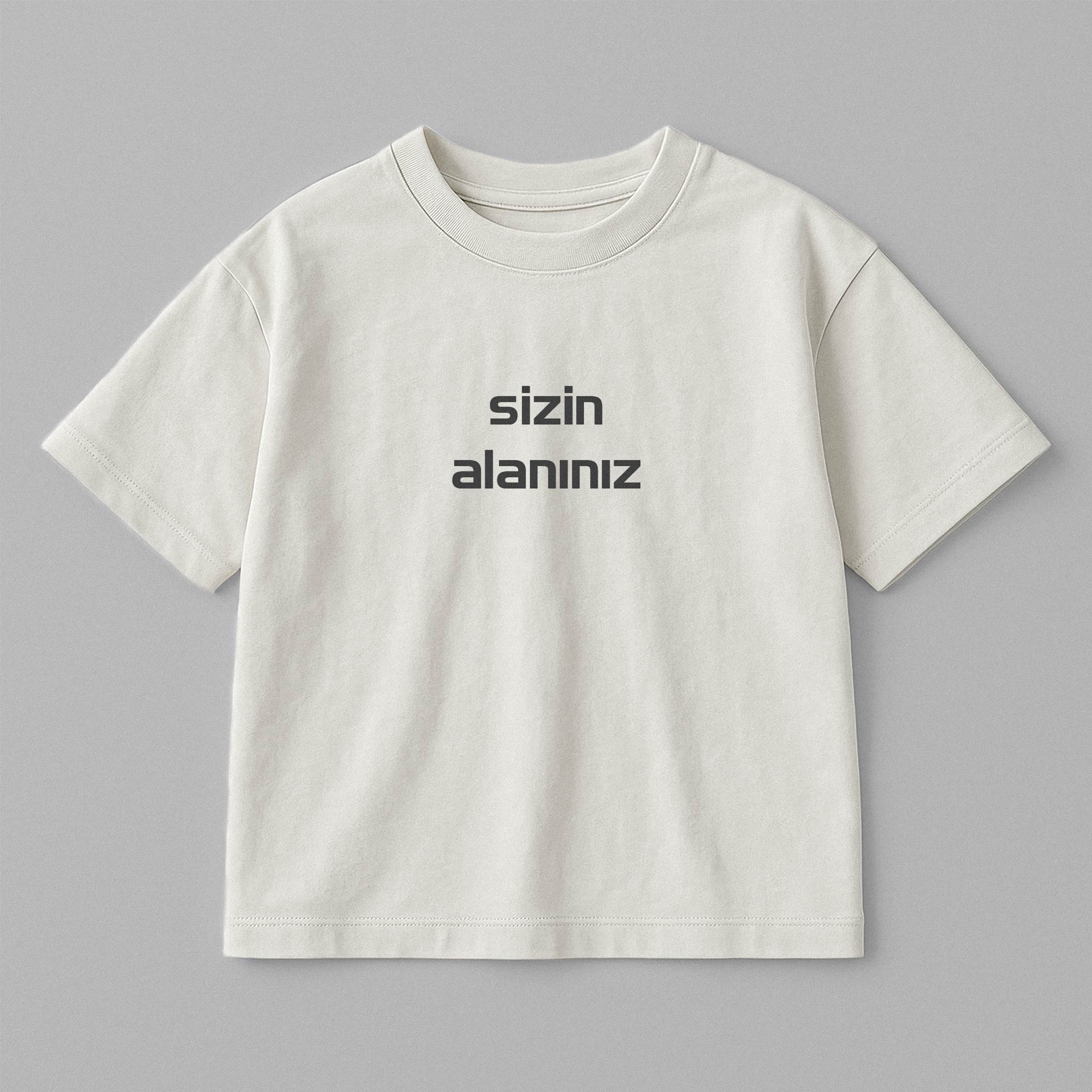 Ekru renkli, oversize kesim, 1-5 yaş için, üzerine istenilen yazının nakışla işlenebildiği pamuklu çocuk tişörtü.