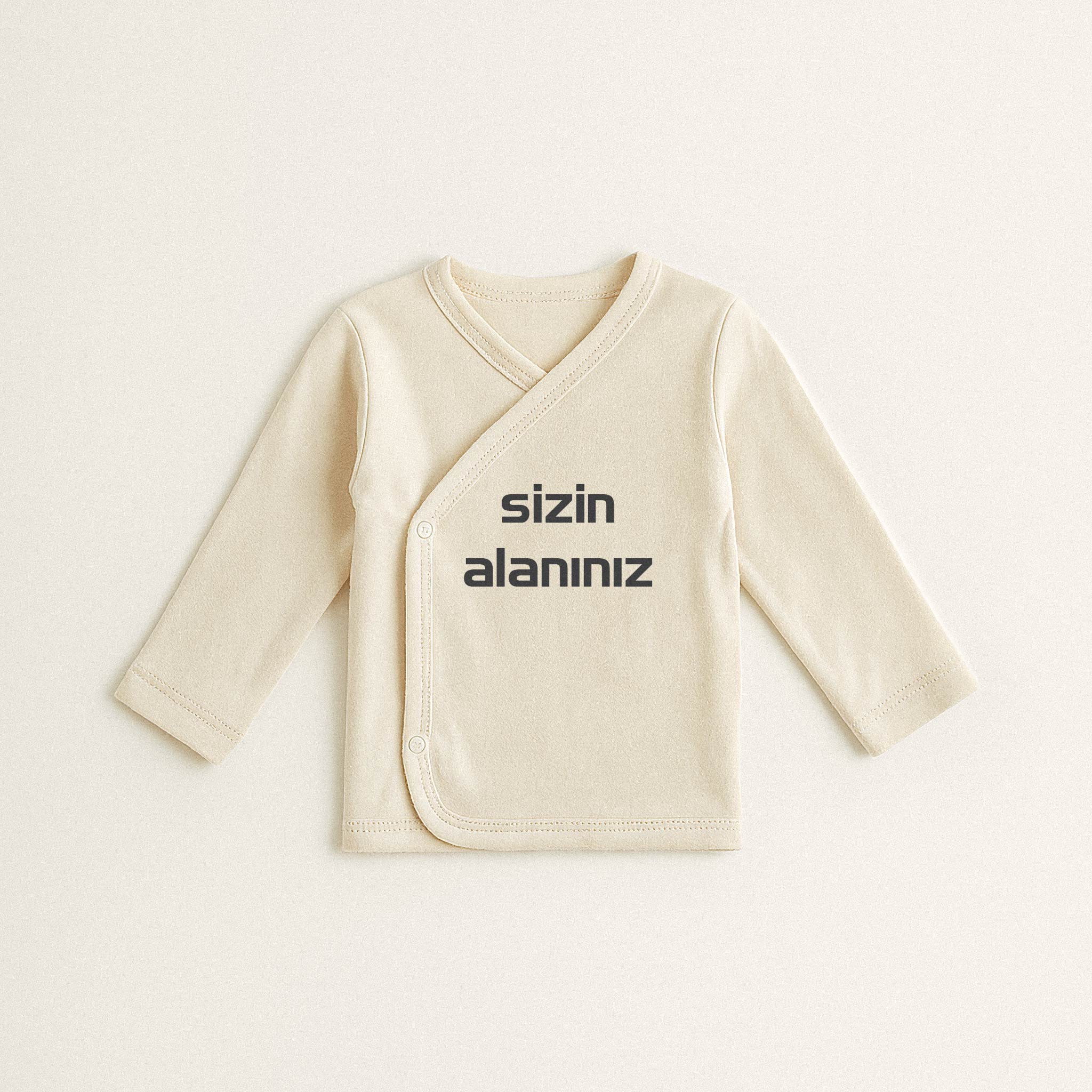 Ekru renkli, %100 pamuklu, uzun kollu, üzerine istenilen yazının nakışla işlenebildiği, yandan çıtçıtlı kruvaze yenidoğan üst.