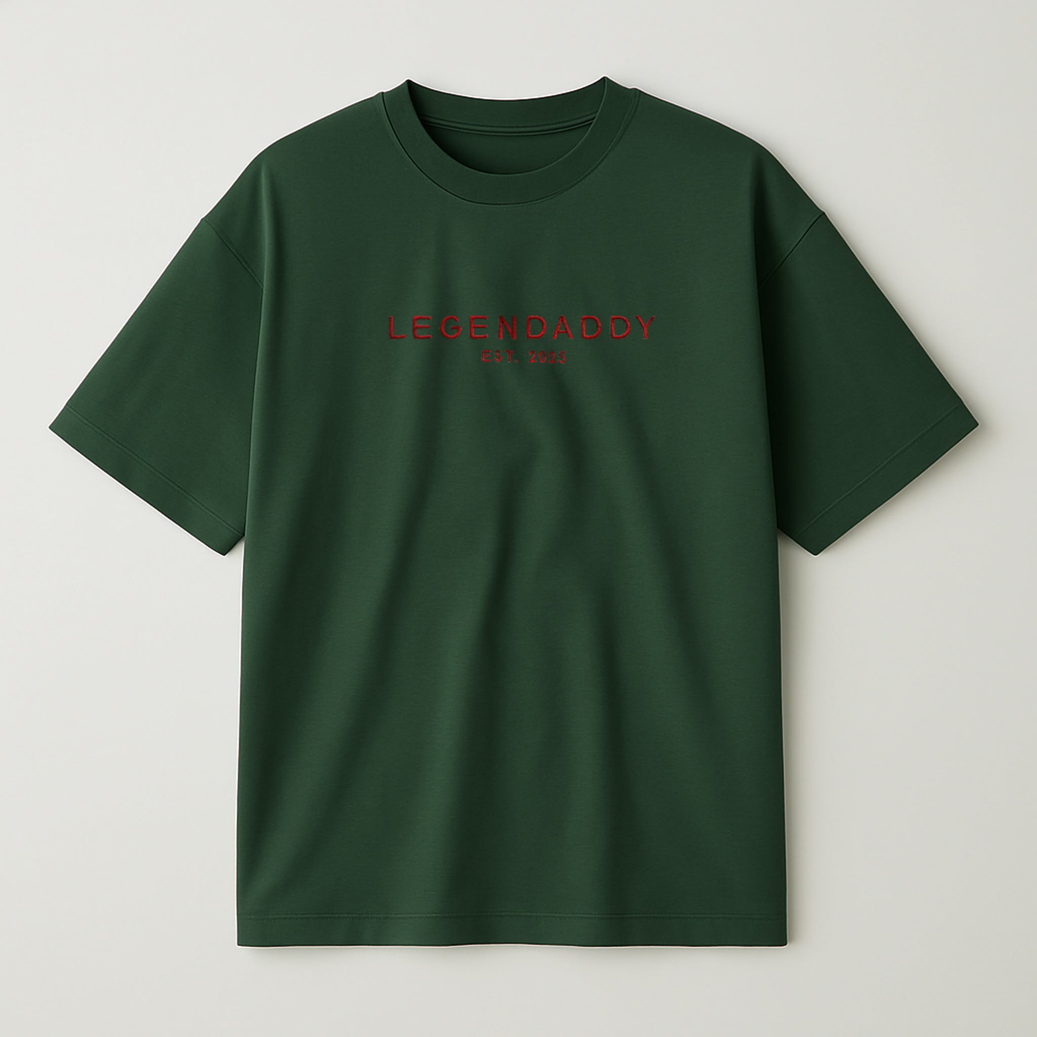 Koyu yeşil renkli, oversize kesim, göğüs kısmında kırmızı iplikle 'LEGENDADDY' yazısı ve altında kişiselleştirilebilir 'EST. YYYY' tarihi nakışla işlenmiş pamuklu unisex tişört.