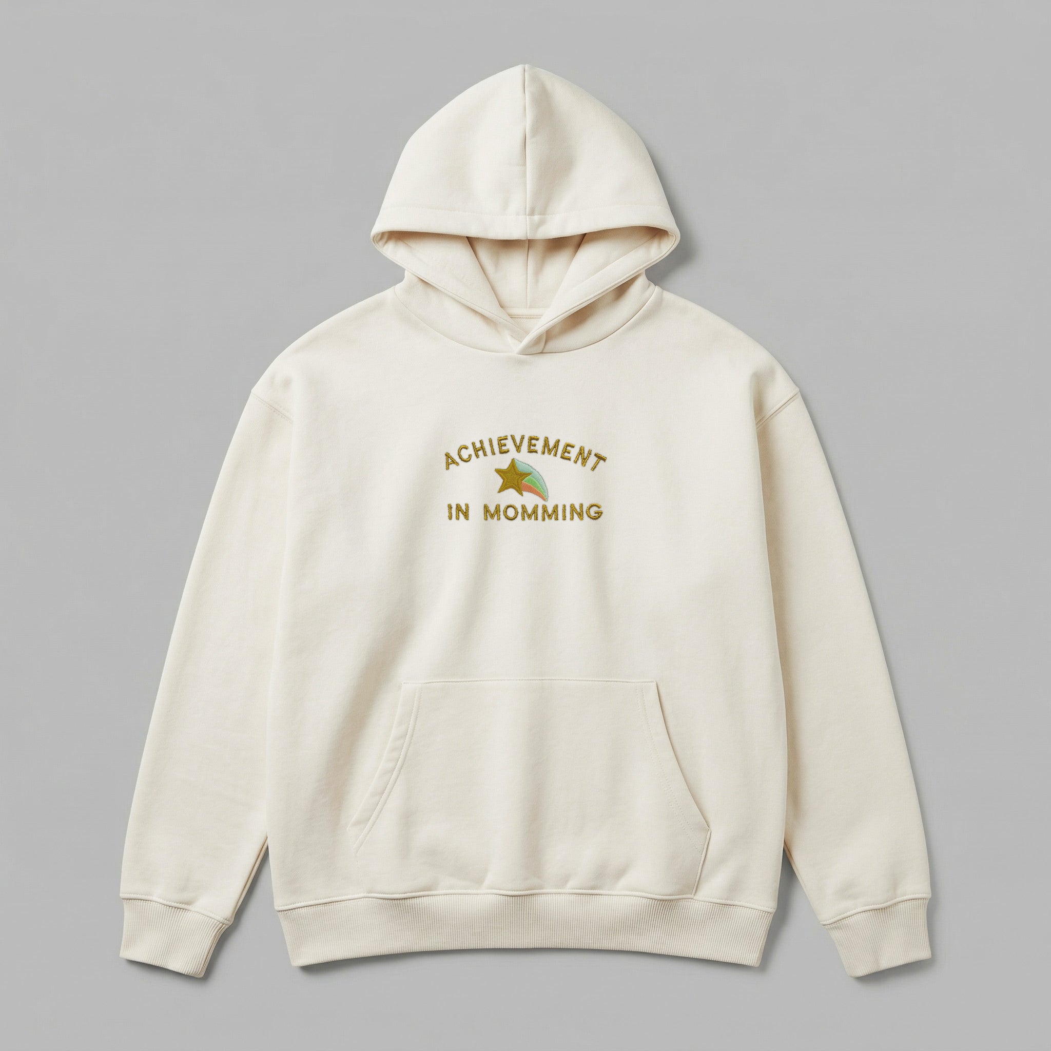 Annelikteki başarıları tatlı bir yolla kutlayan Achievement in Momming yıldız nakışlı krem renkli premium kadın kapüşonlu sweatshirt. %65 pamuklu rüzgar kesen kumaşı ve içi şardonlu kalın polar dokusuyla soğuğa karşı tam koruma sağlar, nefes alan yapısıyla terletmez. Oeko-Tex sertifikalı bu dökümlü model; yüksek kaliteli Alman nakış işçiliği, dayanıklı kanguru cebi ve kalın ribana detaylarıyla anneler için hem anlamlı bir hediye hem de konforlu bir kışlık giyim seçeneğidir.