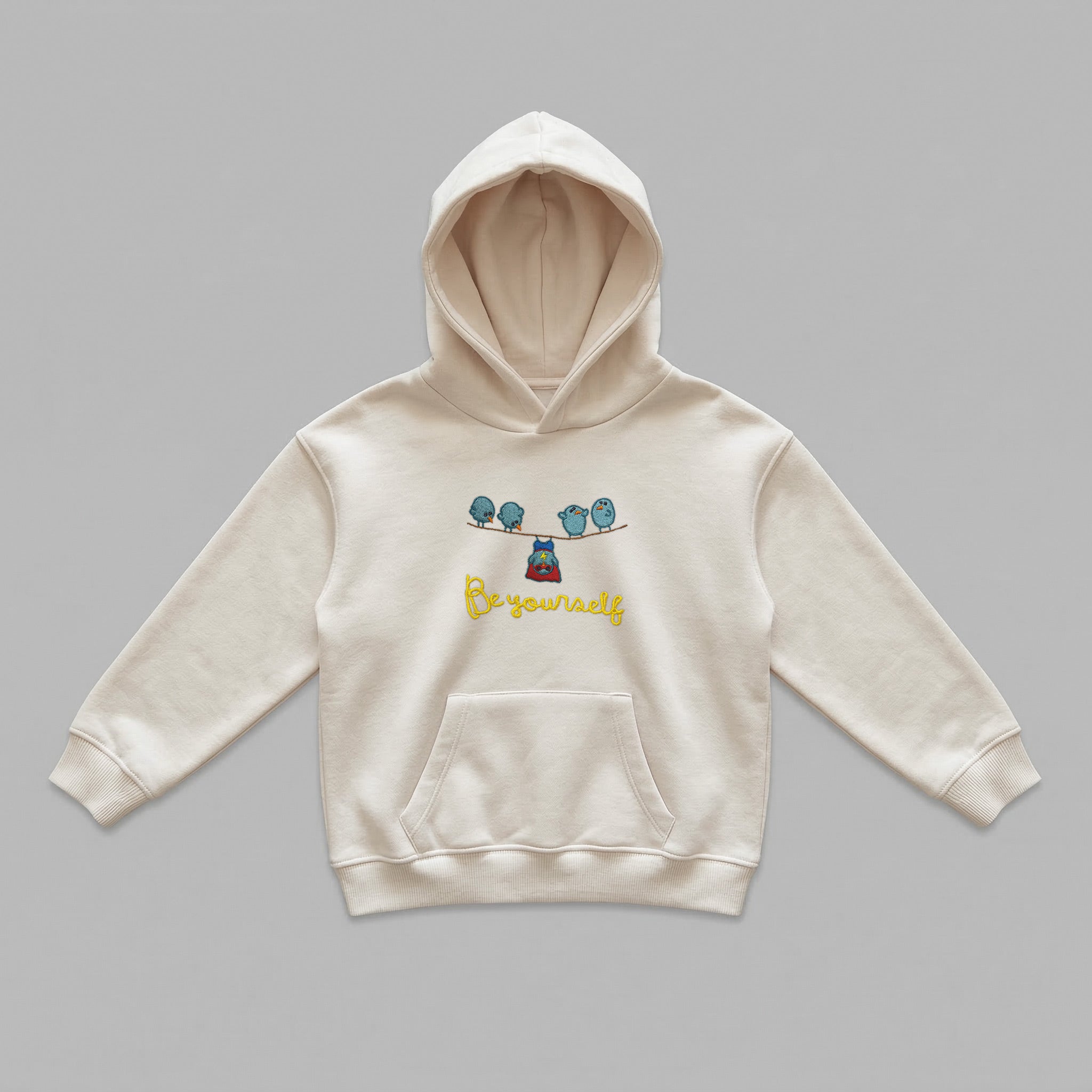 Krem renkli, Oeko-Tex sertifikalı kalın polar çocuk kapüşonlu sweatshirt. Göğsünde teldeki dört kuş, kırmızı pelerinli sarkan süper kahraman kuş figürü ve sarı renkli "Be yourself" nakışı bulunur. İçi şardonlu dokusu kışın sıcak tutar, terletmez. Yüksek kalite Alman işçiliğiyle üretilmiş kanguru cepli, premium kışlık çocuk tasarımı.