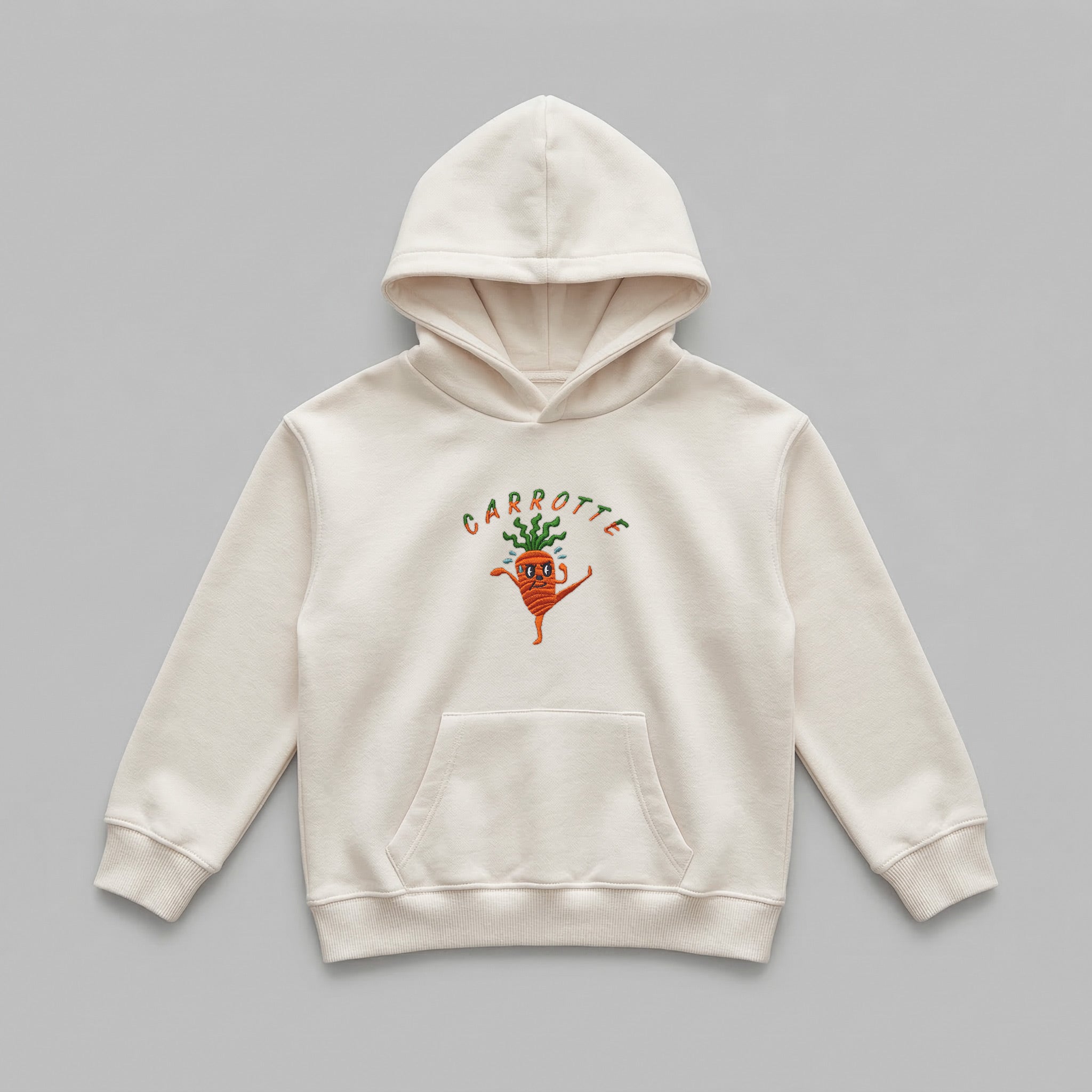 Krem %100 pamuklu Oeko-Tex sertifikalı kalın polar çocuk hoodie. Sol göğsünde iki renkli arc 'CARROTTE' yazısı ve karate yapan havuç nakışı bulunur. Fermuarsız tasarımı, kanguru cebi, içi şardonlu sıcak tutan ve terletmeyen dokusuyla kış boyu konfor sunar. Yüksek kalite Alman nakış işçiliğiyle üretilmiş premium kışlık çocuk sweatshirt detayı.