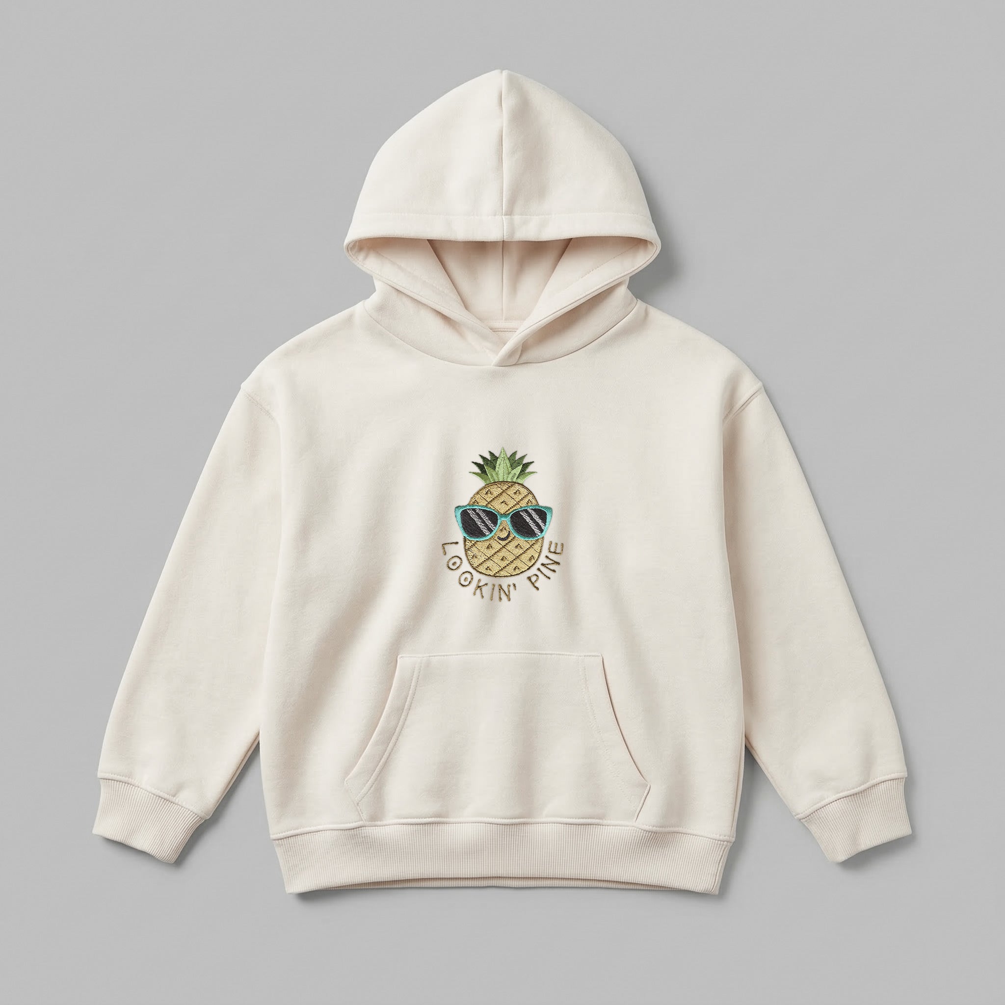 Güneş gözlüğü takan sevimli ananas ve kahverengi tonlarında "LOOKIN' PINE" nakışlı, krem renkli premium polar çocuk hoodie. Oeko-Tex sertifikalı kalın polar kumaş, Alman nakış işçiliği. Eğlenceli ve konforlu çocuk kışlık üst giyim.