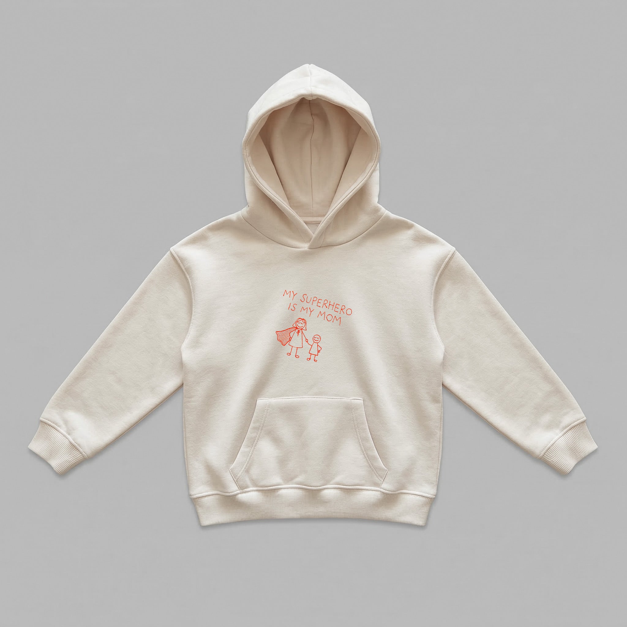 Anneler ve çocukları arasındaki sevgiyi yansıtan, çocuk çizimi detaylı My Superhero Is My Mom nakışına sahip krem renkli çocuk kapüşonlu sweatshirt. İçi kalın polar kumaşıyla kış aylarında rüzgarı kesip sıcak tutarken, nefes alan yapısıyla terleme yapmaz. Kanguru cebi ve esnek manşetleriyle 2-7 yaş çocuklar için idealdir. Oeko-Tex sertifikalı ve Alman nakış işçiliğiyle üretilmiş uzun ömürlü, pürüzsüz yüzeyli premium kışlık giyim.