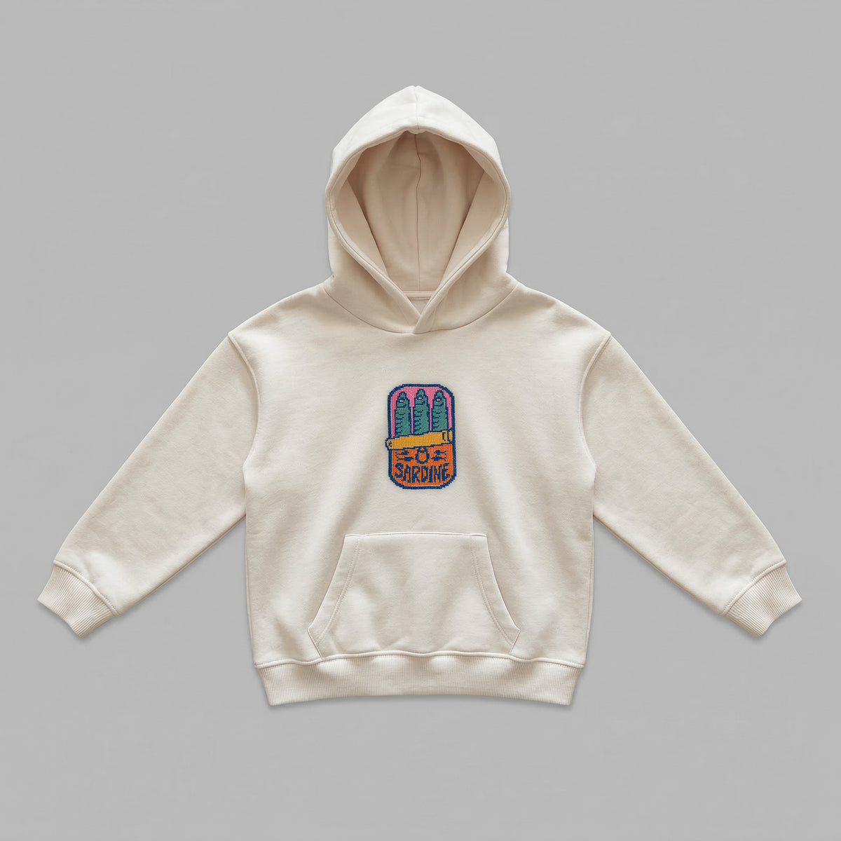 Krem renkli, Oeko-Tex sertifikalı polar çocuk kapüşonlu sweatshirt. Göğüs kısmında retro pixel art temalı, kanaviçe (cross stitch) tekniği görünümüyle işlenmiş renkli konserve sardalya figürü yer alır. İçi şardonlu nefes alan dokusu; serin yaz akşamlarında, bahar ve kış aylarında üşütmez, terletmeden konfor sağlar. Fermuarsız tasarımı, kanguru cebi ve birinci sınıf Alman nakış ipliği kullanılarak özenle üretilmiş, çocukların stiline nostaljik ve eğlenceli bir dokunuş katan premium tasarım.