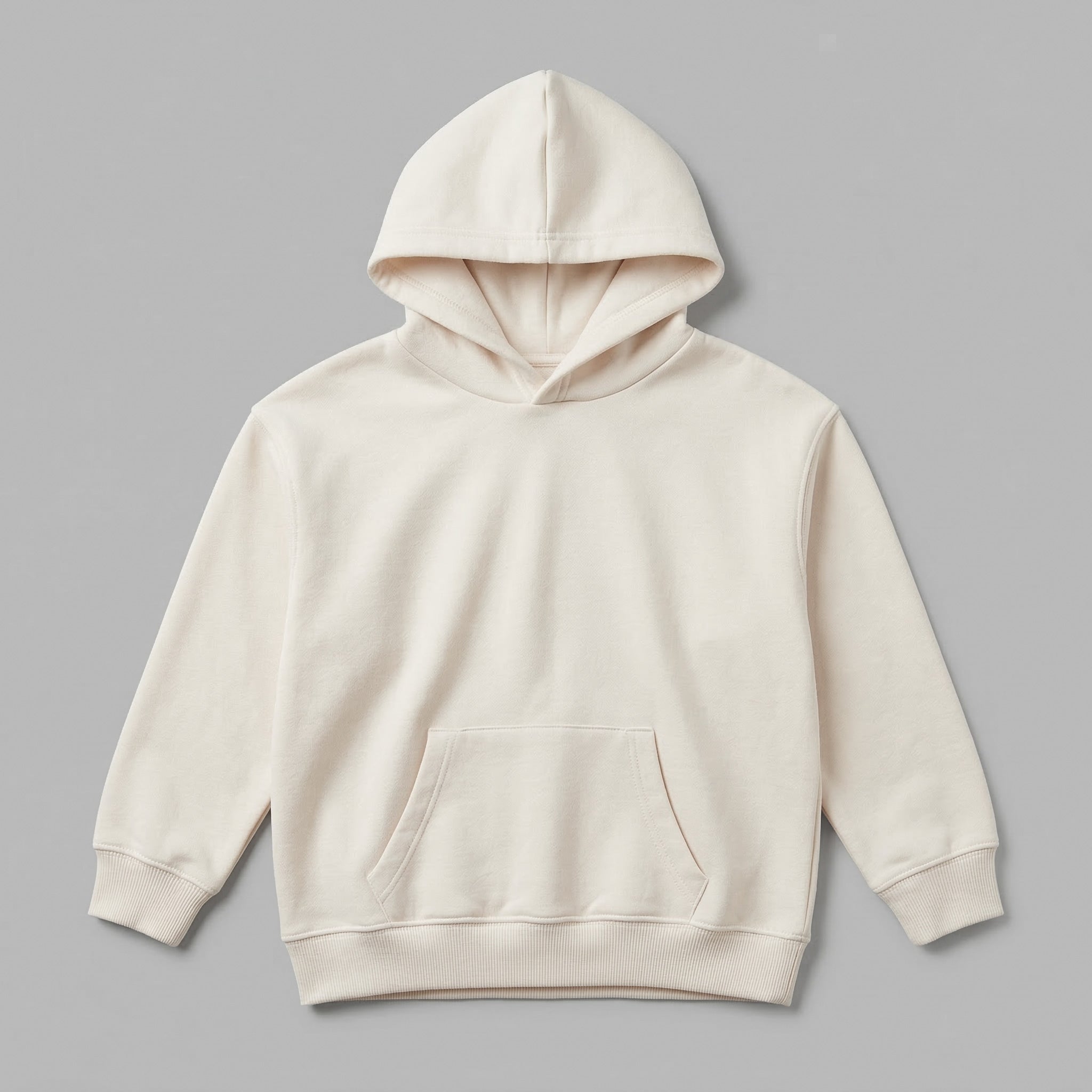 Kendi yaratıcı tasarımlarınızı sergilemeniz için hazırlanan, krem renkli boş çocuk kapüşonlu sweatshirt mockup modeli. %65 pamuklu rüzgar kesen kumaşı ve içi kalın şardonlu yapısıyla soğuk kış günlerinin vazgeçilmez kalitesini yansıtır. Çocukların hassas cildine dost, nefes alan ve terletmeyen premium dokusu görselde netçe hissedilir. 2-7 yaş kalıbında, esnek etek ucu ve kanguru cebiyle tasarlanan, kişiselleştirmeye uygun dayanıklı ve şık bir zemin sunar.