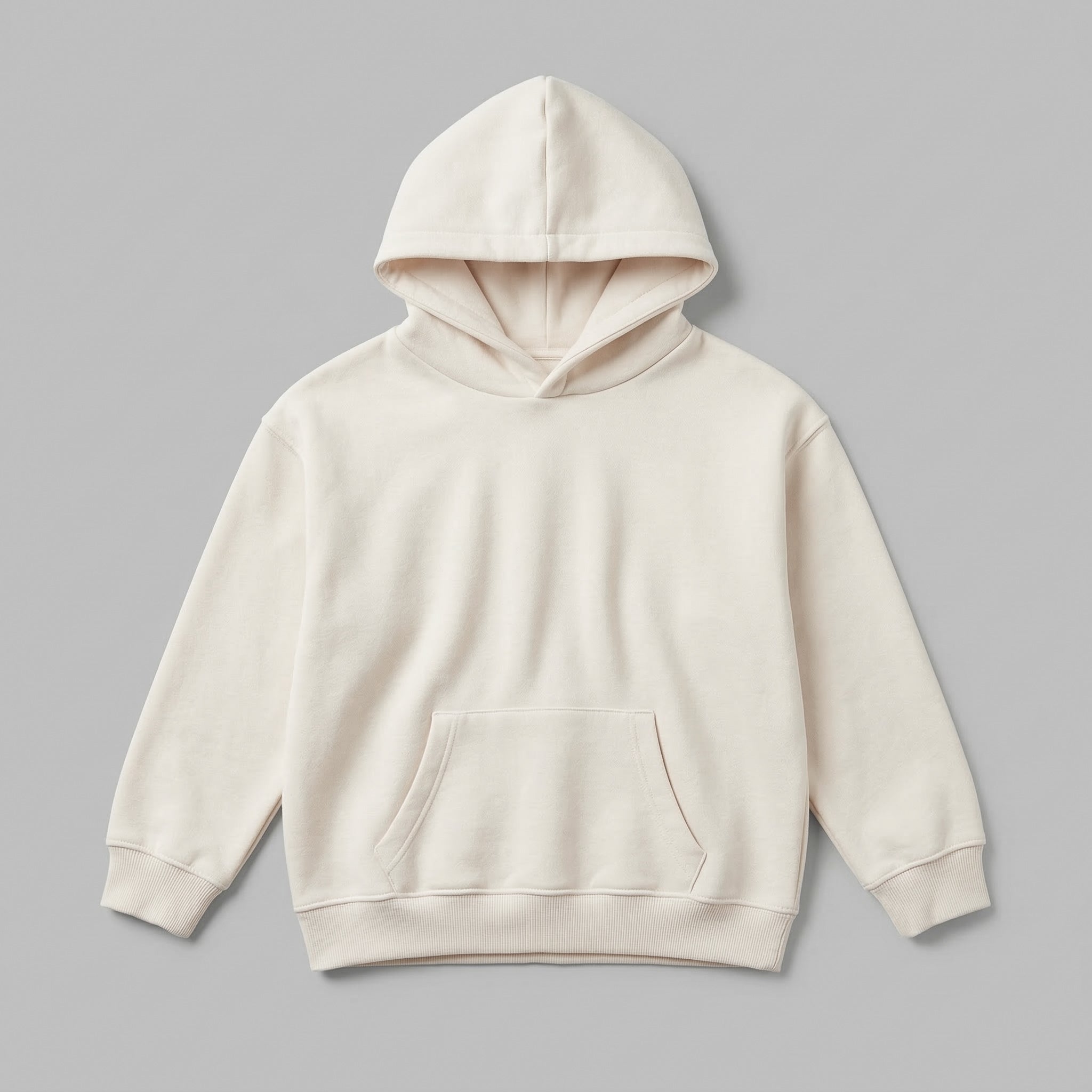 Kendi yaratıcı tasarımlarınızı sergilemeniz için hazırlanan, krem renkli boş çocuk kapüşonlu sweatshirt mockup modeli. %65 pamuklu rüzgar kesen kumaşı ve içi kalın şardonlu yapısıyla soğuk kış günlerinin vazgeçilmez kalitesini yansıtır. Çocukların hassas cildine dost, nefes alan ve terletmeyen premium dokusu görselde netçe hissedilir. 2-7 yaş kalıbında, esnek etek ucu ve kanguru cebiyle tasarlanan, kişiselleştirmeye uygun dayanıklı ve şık bir zemin sunar.