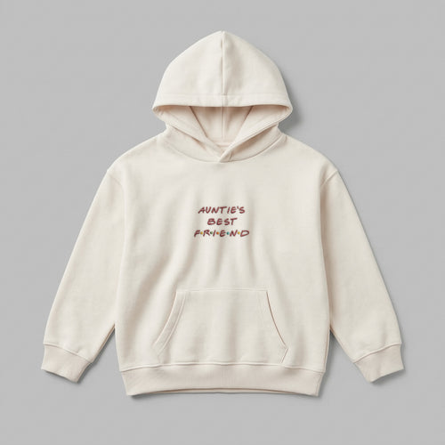 2-7 yaş grubu için tasarlanmış krem renkli çocuk kapüşonlu sweatshirt önden görünümü. Teyzelere özel 'AUNTIE'S BEST FRIEND' nakışlı konsept tasarım. %65 pamuklu ve içi şardonlu polar dokusu kış aylarında terletmeden sıcak tutar. Oeko-Tex sertifikalı bu güvenilir hoodie, esnek ribana manşetleri ve kullanışlı kanguru cebiyle konfor ve hareket özgürlüğü sunar. Teyzelerden çocuklara anlamlı bir kışlık hediye seçeneği arayanlar için ideal, kaliteli ve dayanıklı üst giyim.