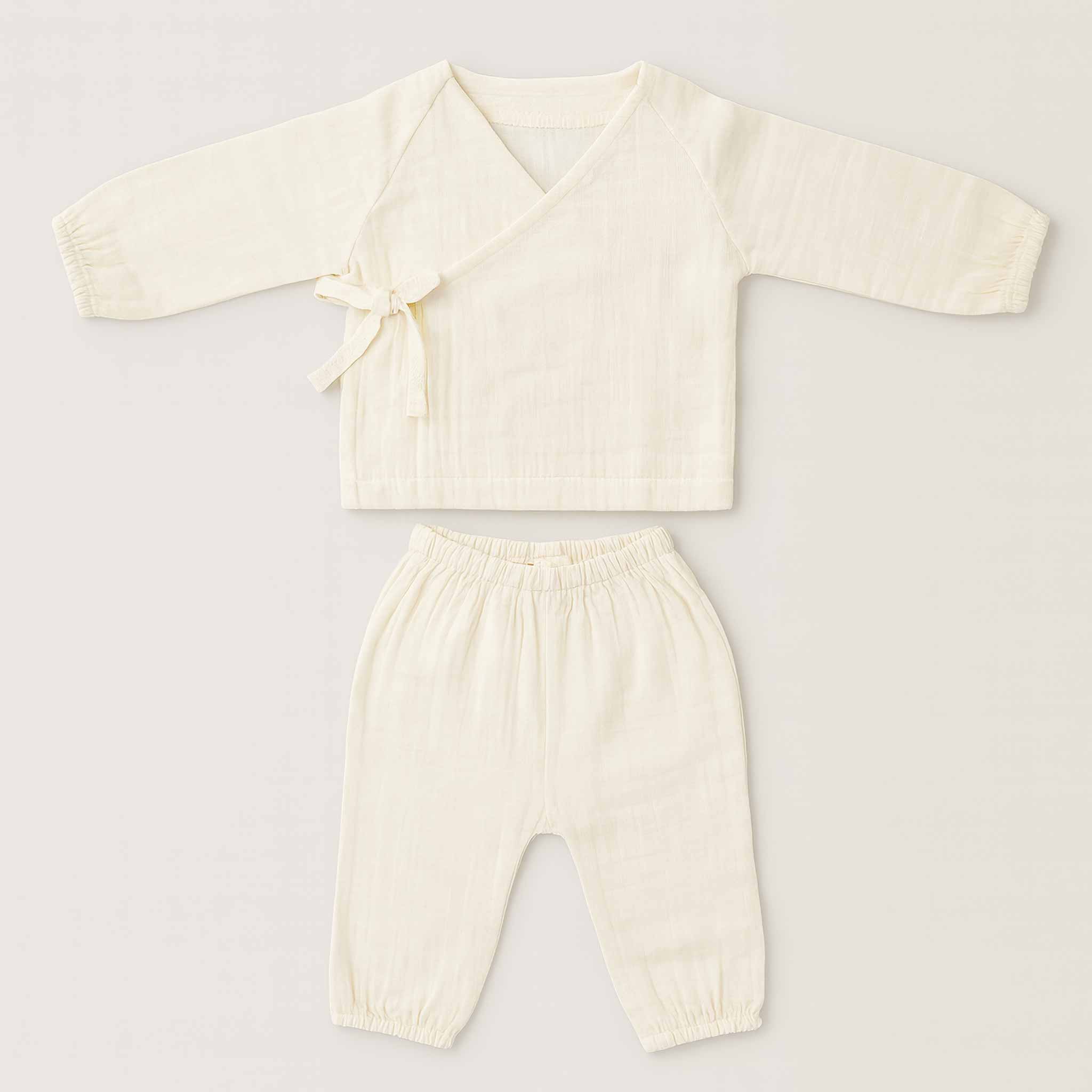 Doğal bej (ekru) renginde, 4 kat müslin kumaştan yapılmış, yandan bağlamalı kimono üst ve pantolondan oluşan yenidoğan bebek takımının düz ön görünümü.