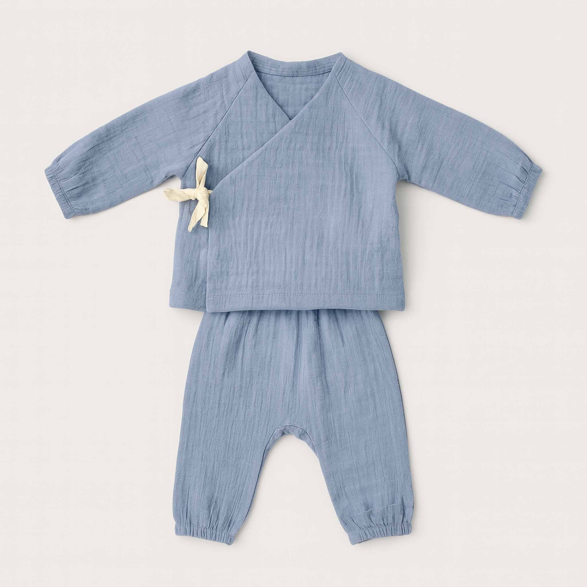 İndigo mavisi renginde, 4 kat müslin kumaştan yapılmış, yandan bağlamalı kimono üst ve pantolondan oluşan yenidoğan bebek takımının düz ön görünümü.