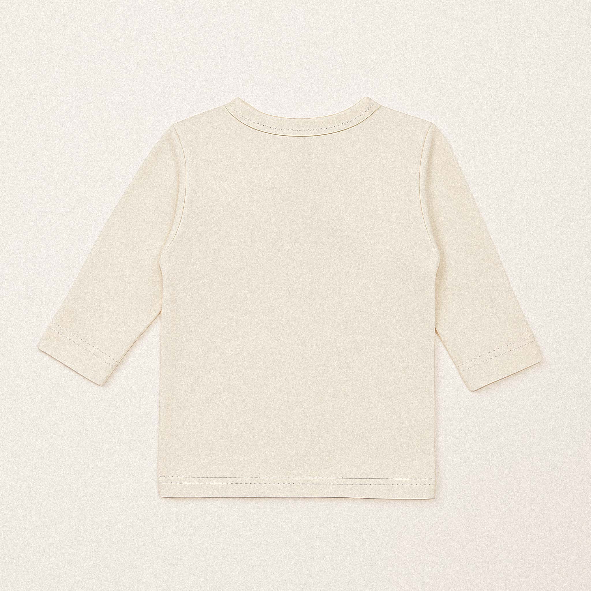 Ekru renkli, organik pamuklu, uzun kollu kruvaze yenidoğan üst giyimin arka tarafının düz görünümü.