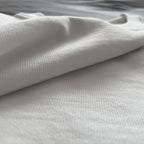 Ekru renkli premium oversize tişörtün %100 pamuklu, nefes alabilen ve yüksek gramajlı kumaş dokusunu çok yakından gösteren makro çekim.