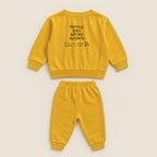 Hardal sarısı renkli, sweatshirt ve pantolondan oluşan pamuklu bebek eşofman takımı. Sweatshirt'ün arka tarafında "REMOVE BABY BEFORE WASHING" yazısı ve yıkama sembolleri işlenmiştir.