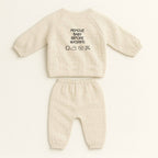 Doğal bej rengi müslin kimono takımının arka görünümü. Üst giyimin sırtında siyah iplikle "REMOVE BABY BEFORE WASHING" yazısı ve yıkama sembolleri işlenmiştir.