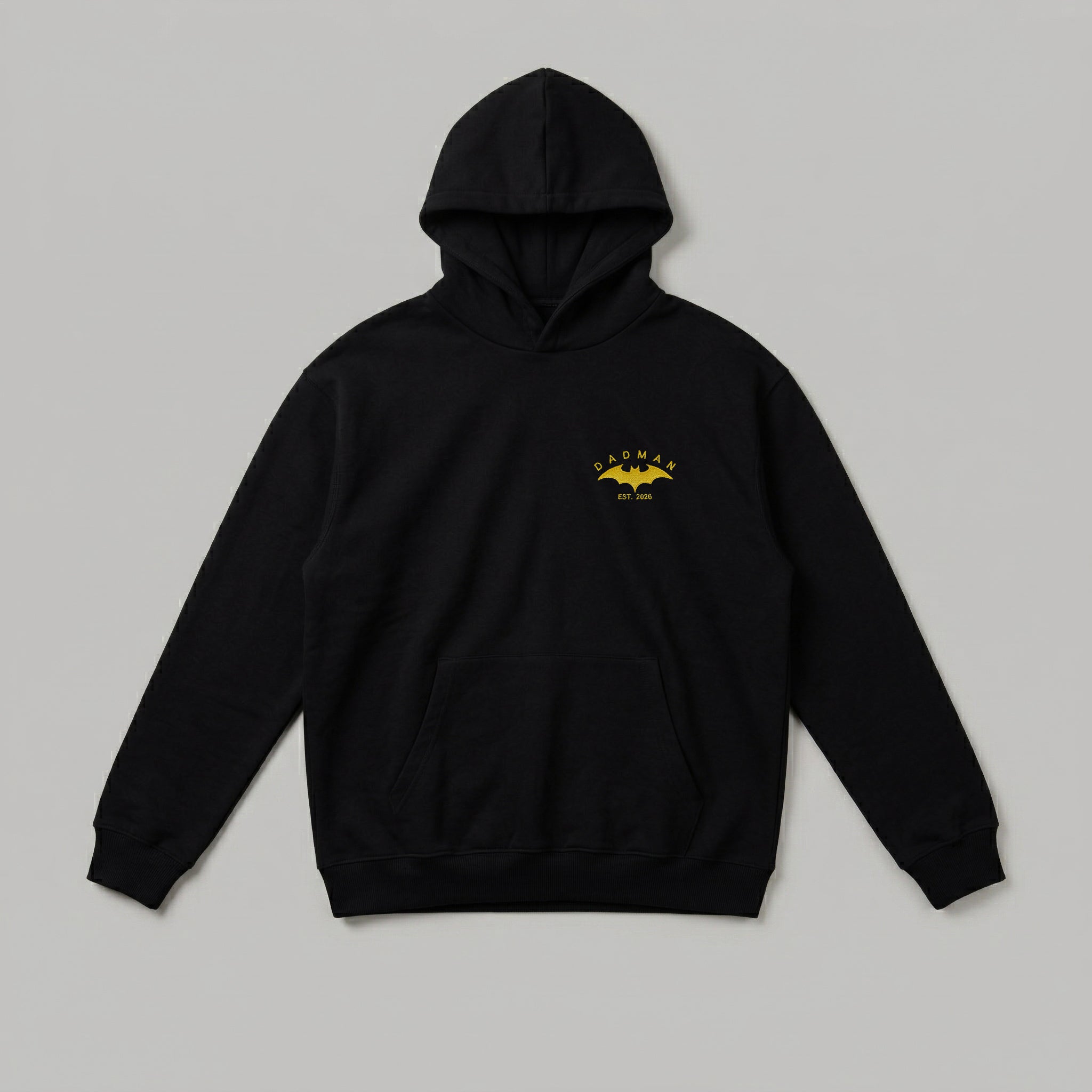 Siyah, Oeko-Tex sertifikalı kalın polar kapüşonlu sweatshirt. Sol göğsünde sarı yarasa figürlü "DADMAN" ve kişiselleştirilebilir baba olma yılı (ör: EST. 2026) nakışı yer alır. İçi şardonludur; sıcak tutar, terletmez. Kanguru cepli ve yüksek kalite Alman nakış işçiliğiyle üretilmiş, babalara özel anı değeri taşıyan premium tasarım.