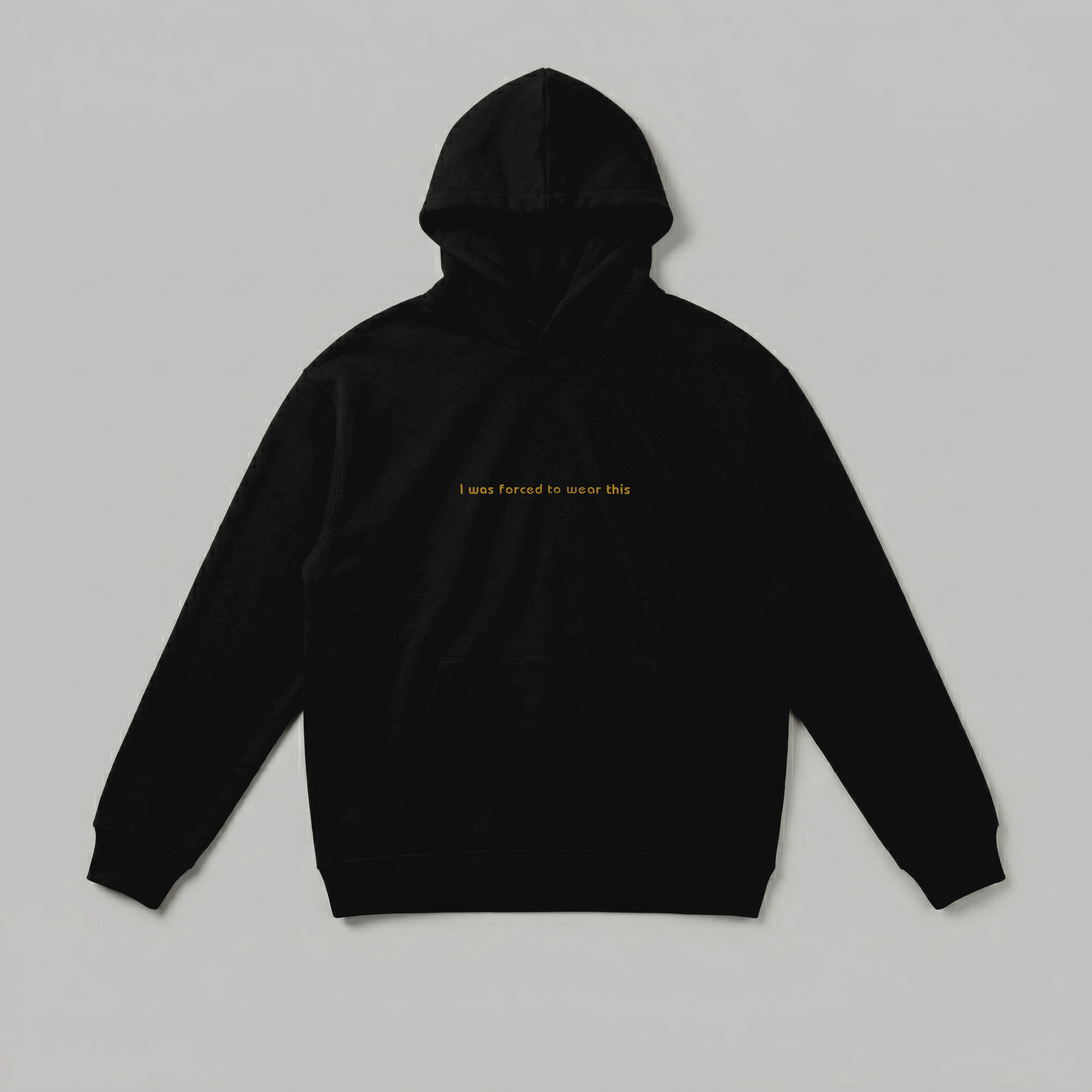 Siyah renkli, Oeko-Tex sertifikalı kalın polar yetişkin kapüşonlu sweatshirt. Göğüs kısmında hardal sarısı minimal fontla işlenmiş "I was forced to wear this" nakışı yer alır. İçi şardonlu dokusu kışın sıcak tutar, rüzgarı keser ve terletmez. Fermuarsız tasarımı, kanguru cebi ve birinci sınıf Alman nakış işçiliğiyle üretilmiştir. Babalar için esprili ve premium kışlık erkek sweatshirt tasarımı.